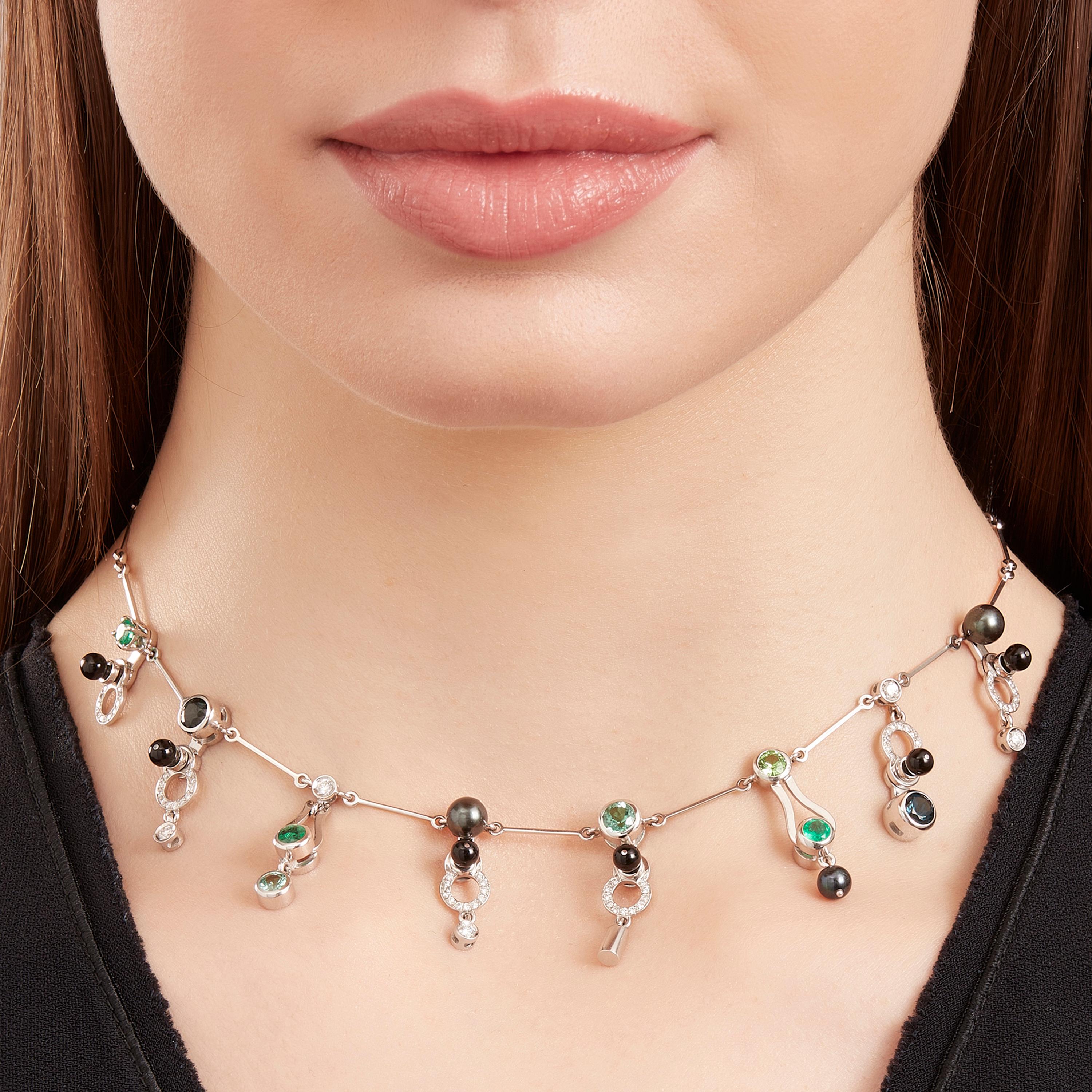 Microrock Choker Necklace is devised as a game, a construction or a sophisticated aerial mobile. Shapes attached to gold rings dangle lightly around the neck, their geometry pierced by diamond (0,58 total carat), emerald, green tourmaline,