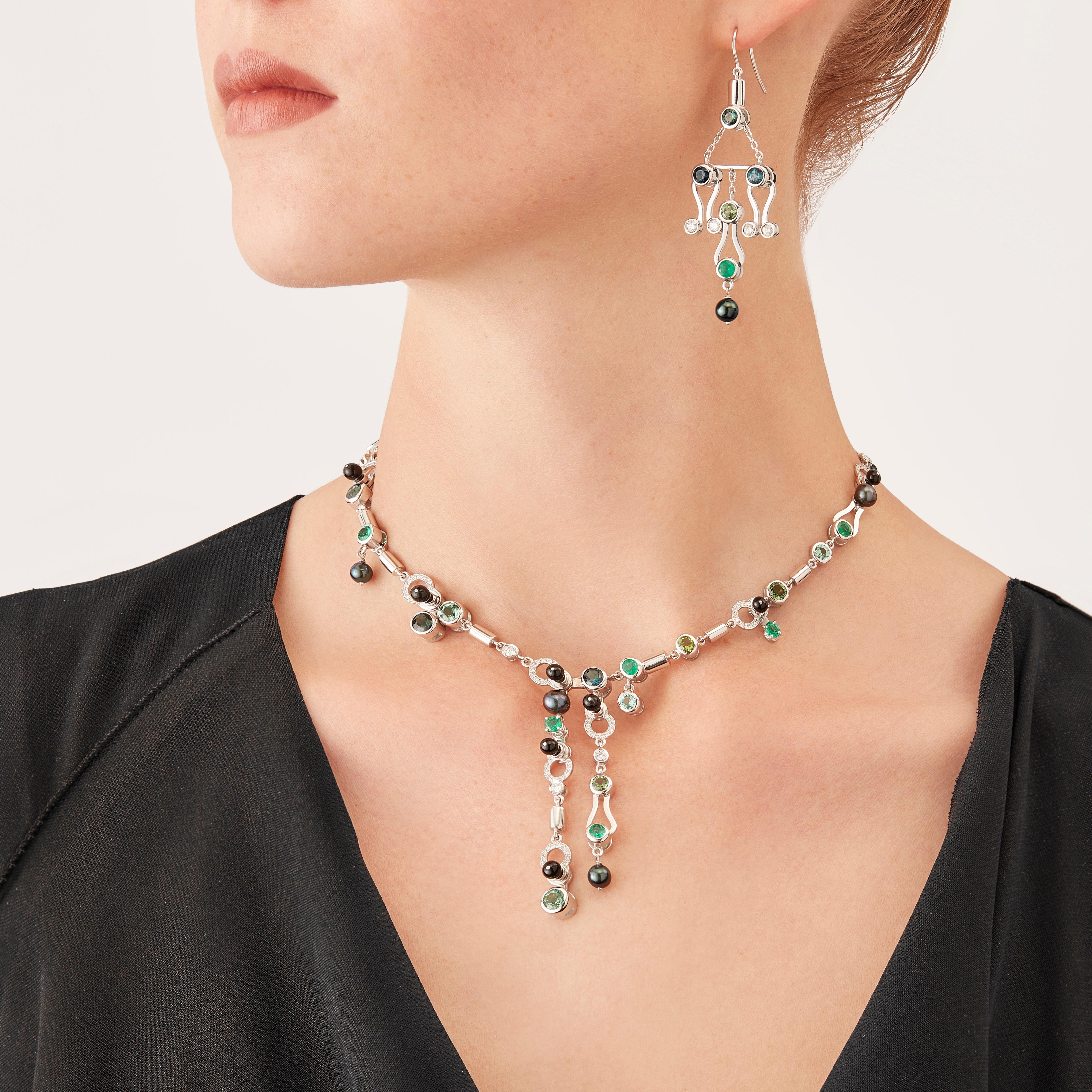 Microrock Necklace is devised as a game, a construction or a sophisticated aerial mobile. Shapes attached to gold rings dangle lightly on the hand, their geometry pierced by diamond (total carat weight 0,79), emerald, green tourmaline, indicolite,