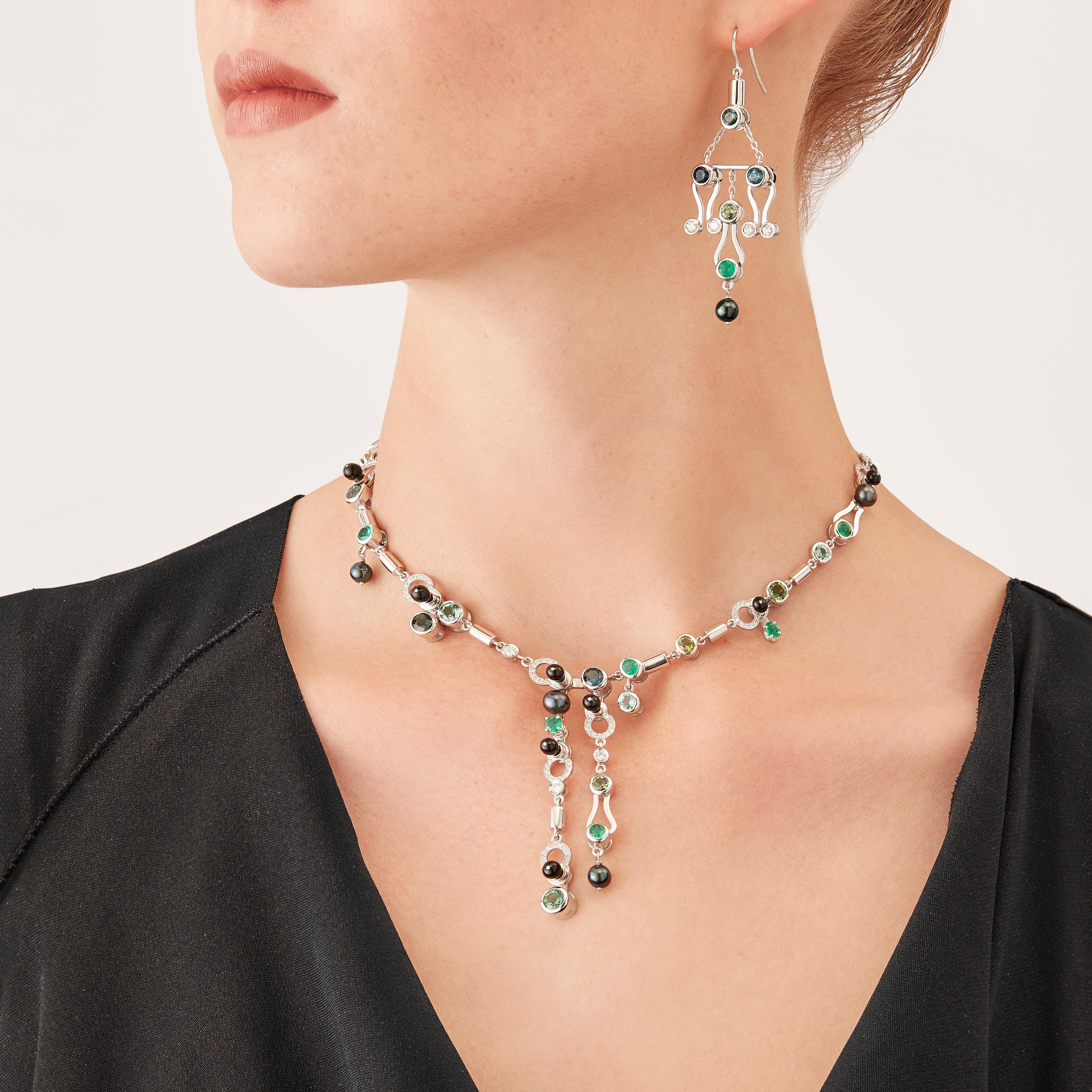 Una pièce unique a più pietre, la Microrock Drop Necklace è concepita come un gioco, una costruzione o un sofisticato mobile aereo. Le forme attaccate agli anelli d'oro penzolano leggermente sulla mano, la loro geometria è trafitta da diamanti (peso