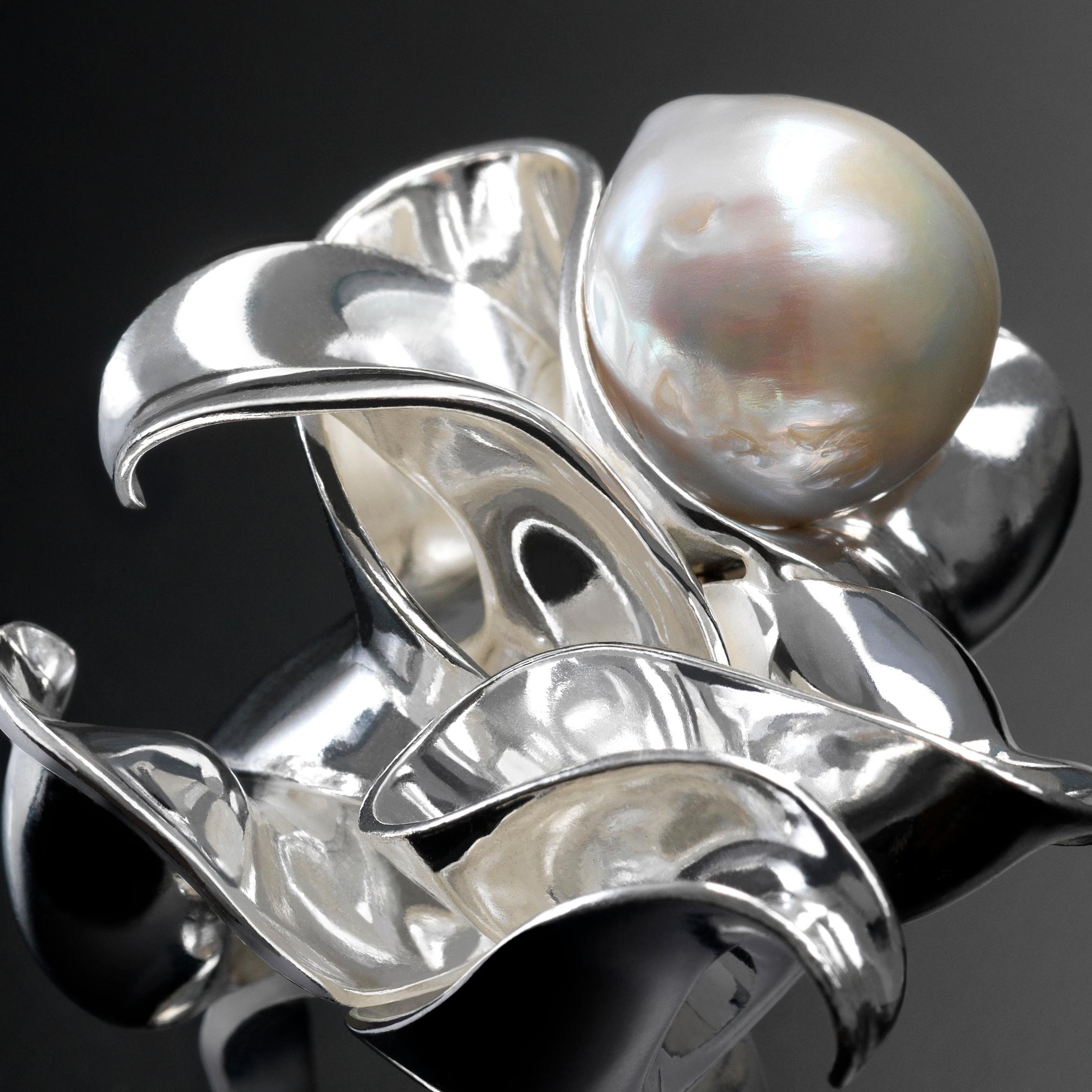 With their delicate, curved, free-form surfaces, the elements of this sculptural statement ring in sterling silver fold and unfold with harmony and grace like shell fragments or metalized leaves. Cleverly fit one into the other, the undulating
