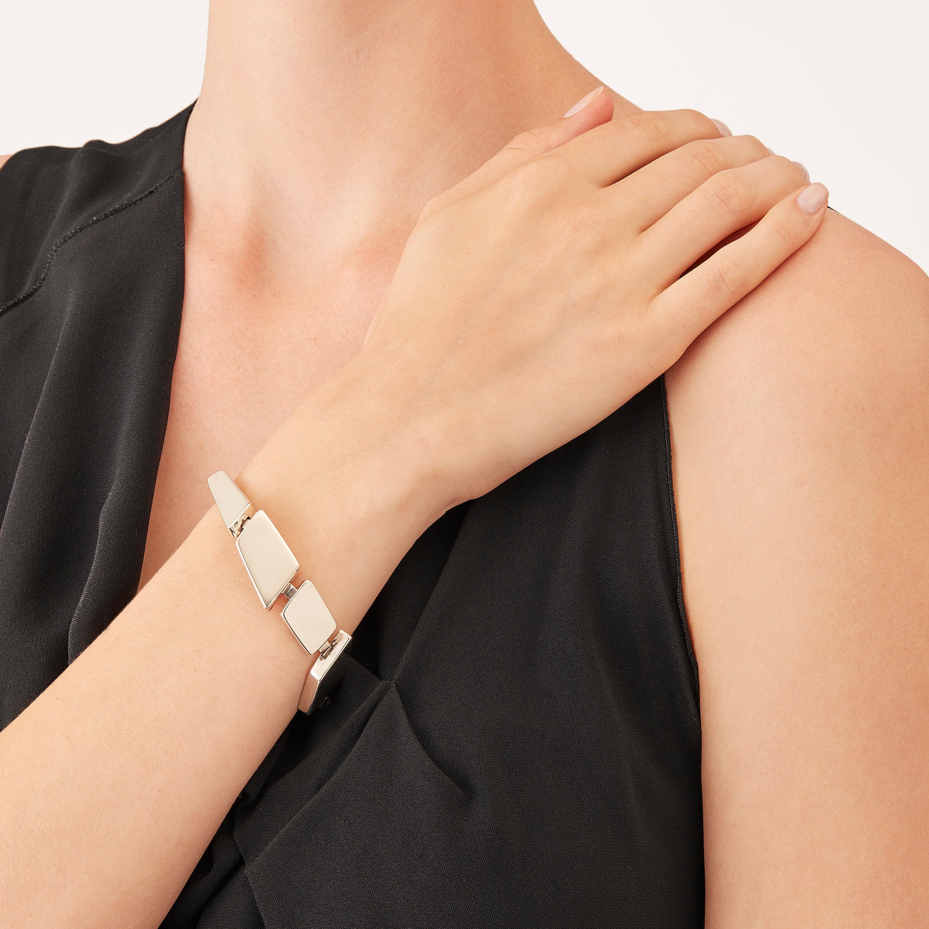 Das in limitierter Auflage im Mailänder Atelier von Nathalie Jean handgefertigte Armband Saphir Absolu besteht aus leichten geometrischen Hohlkörpern mit abgerundeten Kanten aus Sterlingsilber. Dank raffinierter, versteckter Glieder lassen sich die