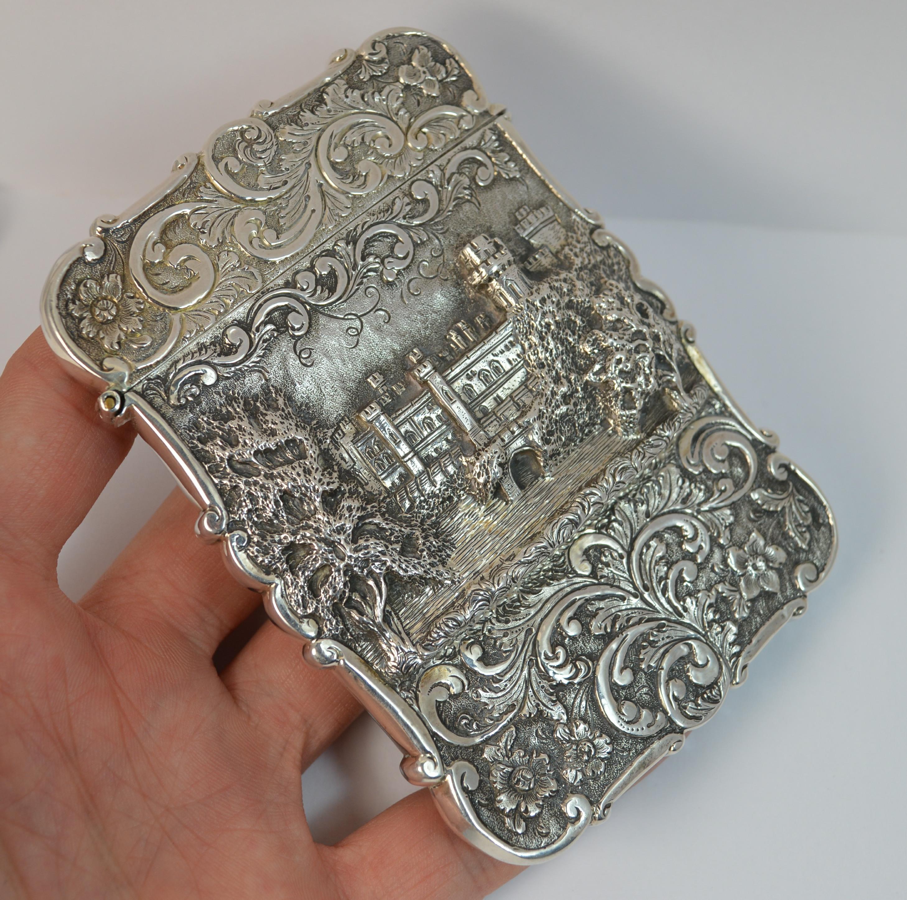 A stunning quality sterling silver card case.

Early Victorian period example by Nathaniel Mills.

The castle top design is of Kenilworth Castle. The castle landscape spreads the width of the case and a deep floral engraved finish runs throughout
