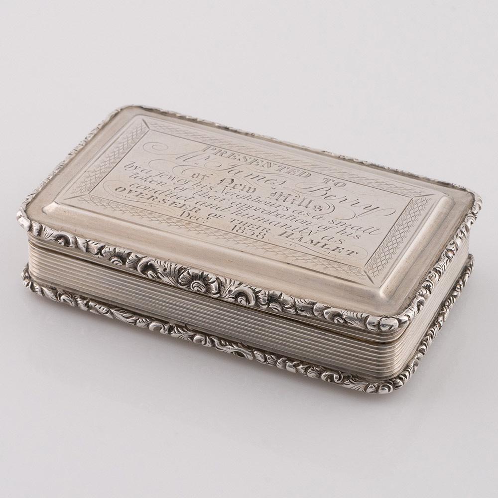 Intitulé : Tabatière en argent Nathaniel Mills avec dédicace
Date : Poinçonné en 1835 à Birmingham pour Mills
Période : Guillaume IV
Origine : Birmingham, Angleterre
Décoration : Motif floral en fonte sur les bordures, corps cannelé, intérieur du