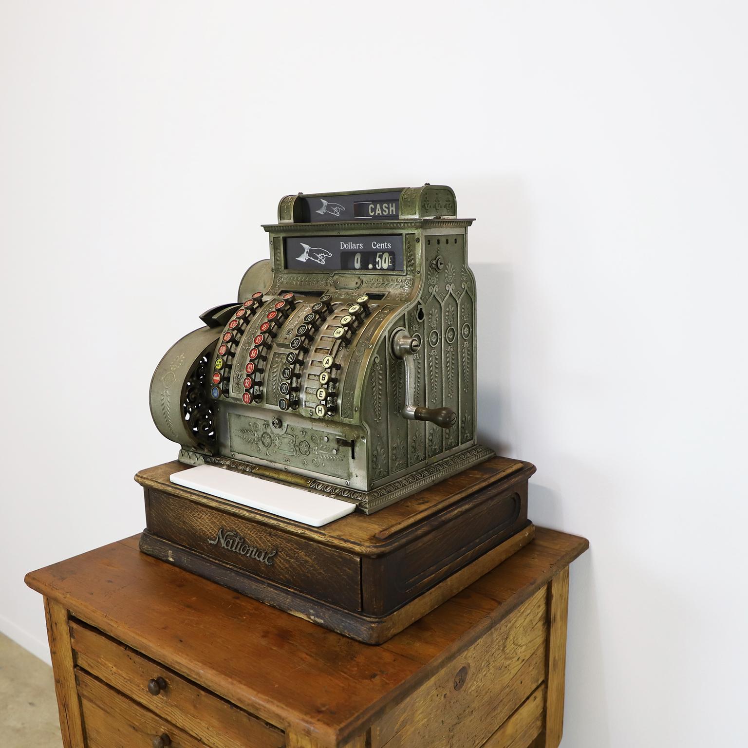 National Cash Register Co. Caisse enregistreuse en laiton, début des années 1900, sur socle en bois.