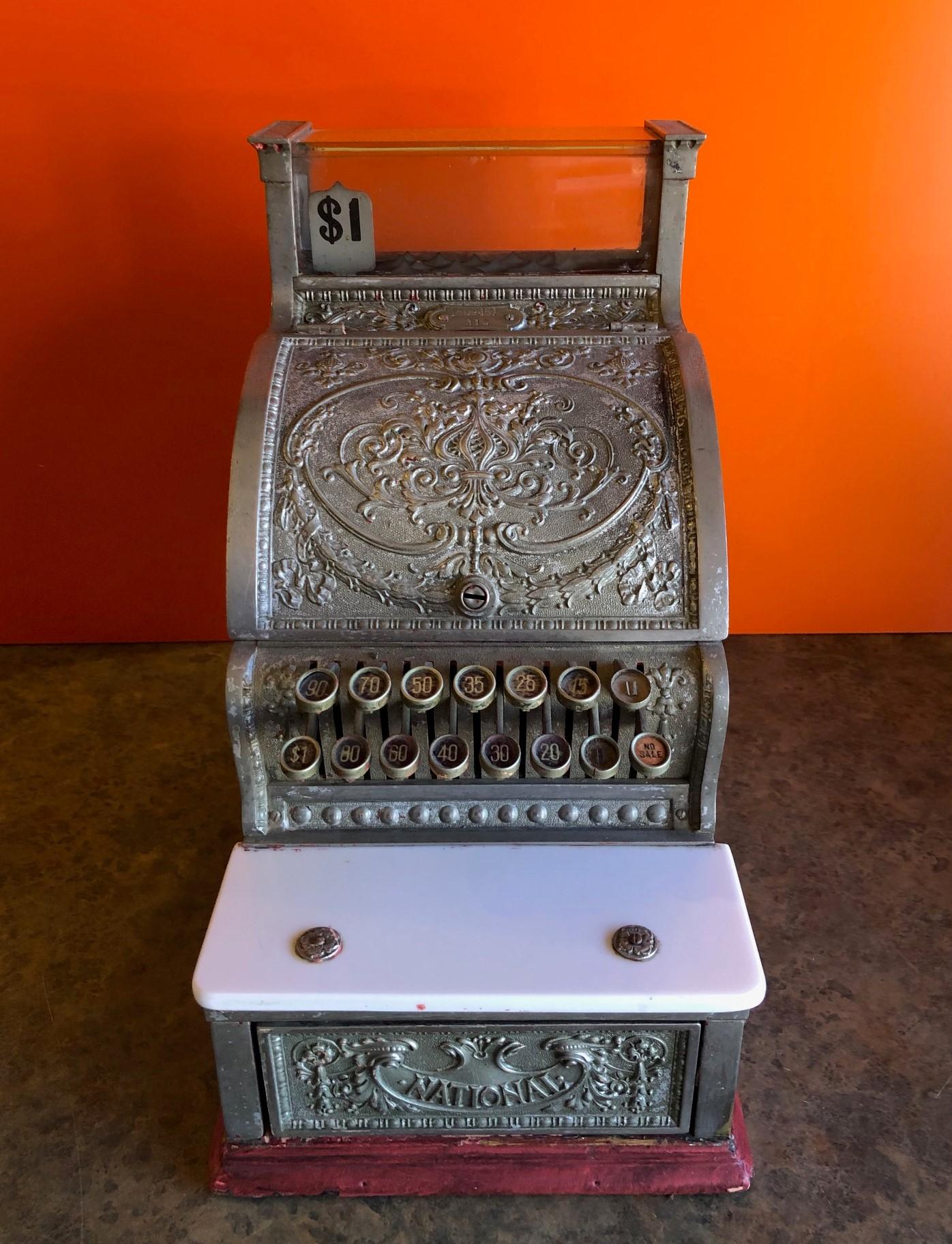 Antique model #313 cash register by National Cash Register (NCR), circa 1915.

The register is nickel plated brass in a very ornate pattern with a white marble shelf in very good condition. This is a beautiful register and was probably in a candy