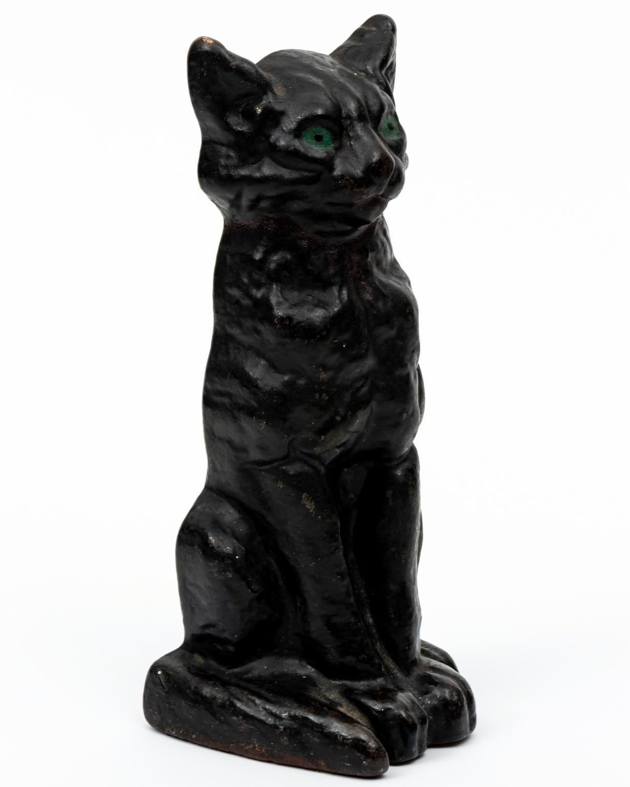 Circa 1920s National Foundry cast iron black cat doorstop with painted green eyes. The piece is heavy and weighs 6 pounds 7 ounces. Made in the United States. Please note of wear consistent with age including wear to paint, which is expected
