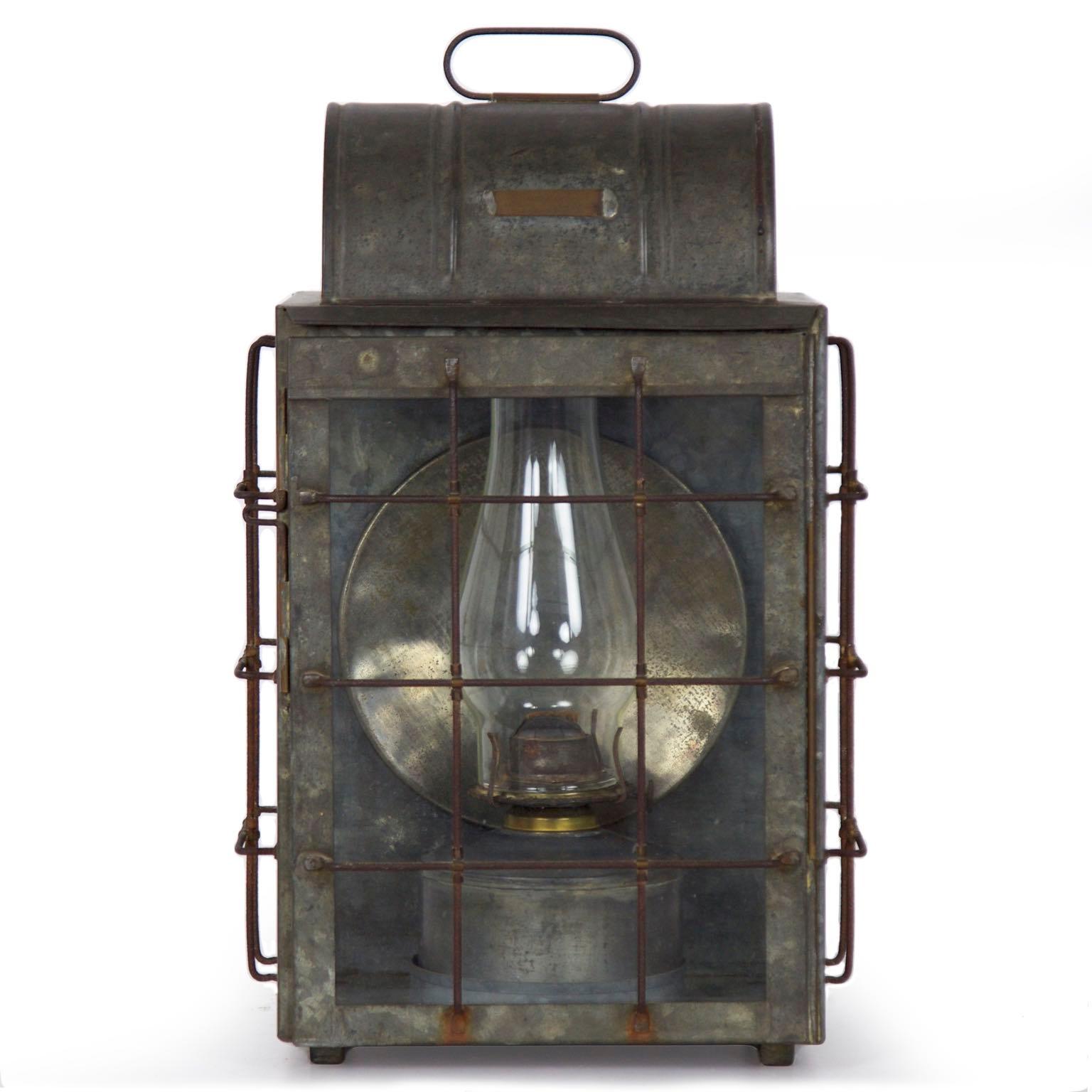 This fine National Marine Lamp Co. bulkhead lantern sports the original brass plaque noting “MFRD by National Marine Lamp Company, New York” and an early hurricane over an original oil lamp. It retains original glass and the surfaces remain