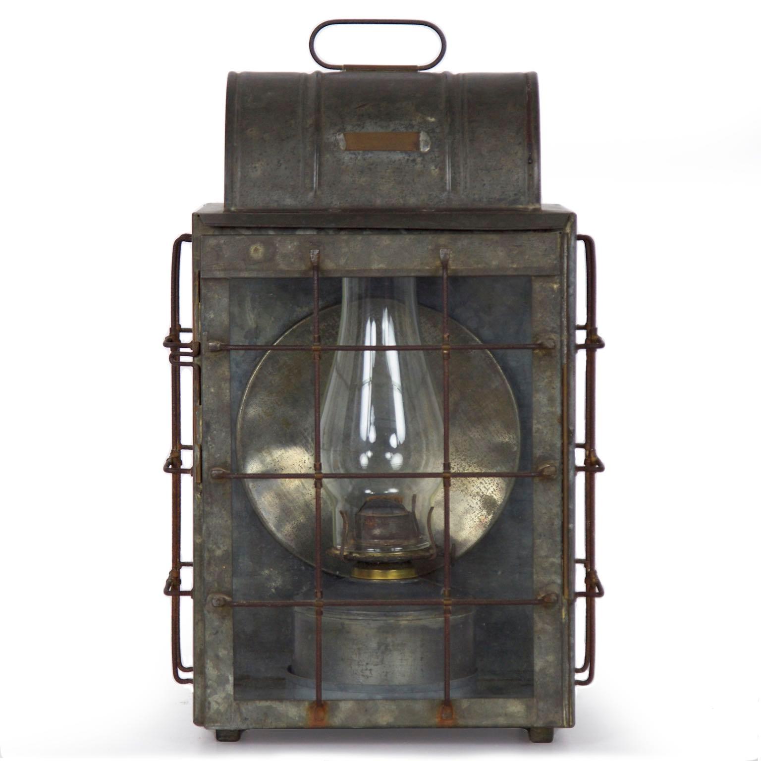 This fine National Marine Lamp Co. bulkhead lantern sports the original brass plaque noting “MFRD by National Marine Lamp Company, New York” and an early hurricane over an original oil lamp. It retains original glass and the surfaces remain