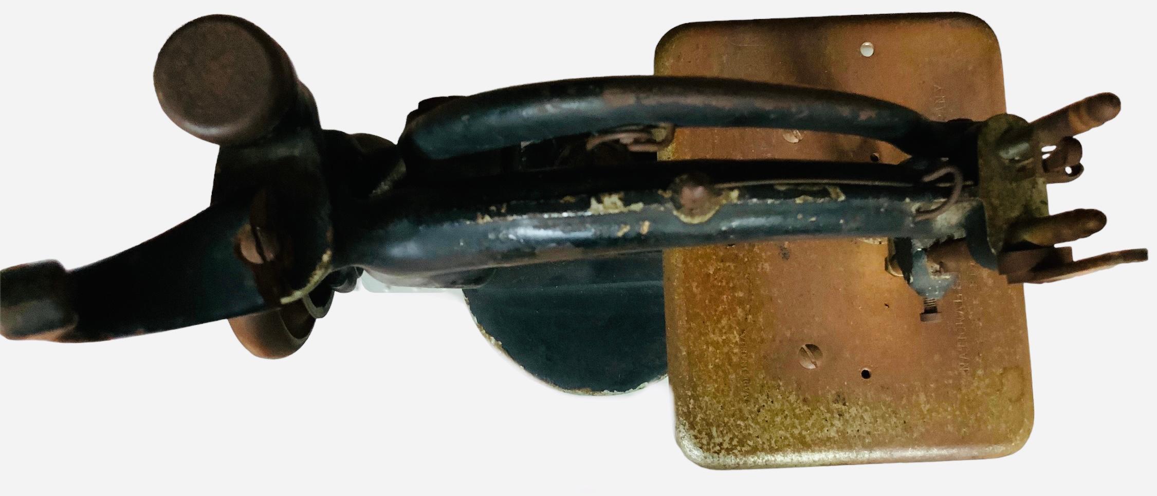 This is a National Sewing Machine Co. B. Eldredge Sewing Machine. It depicts two arcs shaped sewing machine painted black. It is adorned at its round base with a gold oval plaque that identifies it as a B.Eldredge Automatic. This sewing machine is