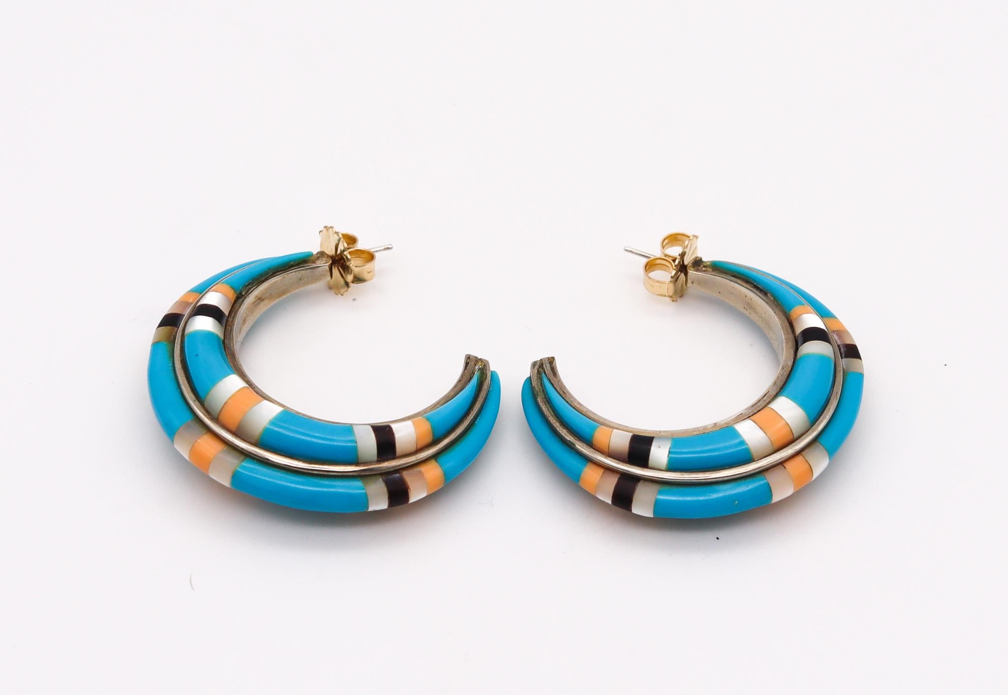 A Native American Navajo hoops earrings

An exceptional tribal piece with gorgeous eye appeal, created in Arizona by the Navajo native Americans back in the 1970's. This unusual colorful pair of hoops earrings was completely crafted in solid