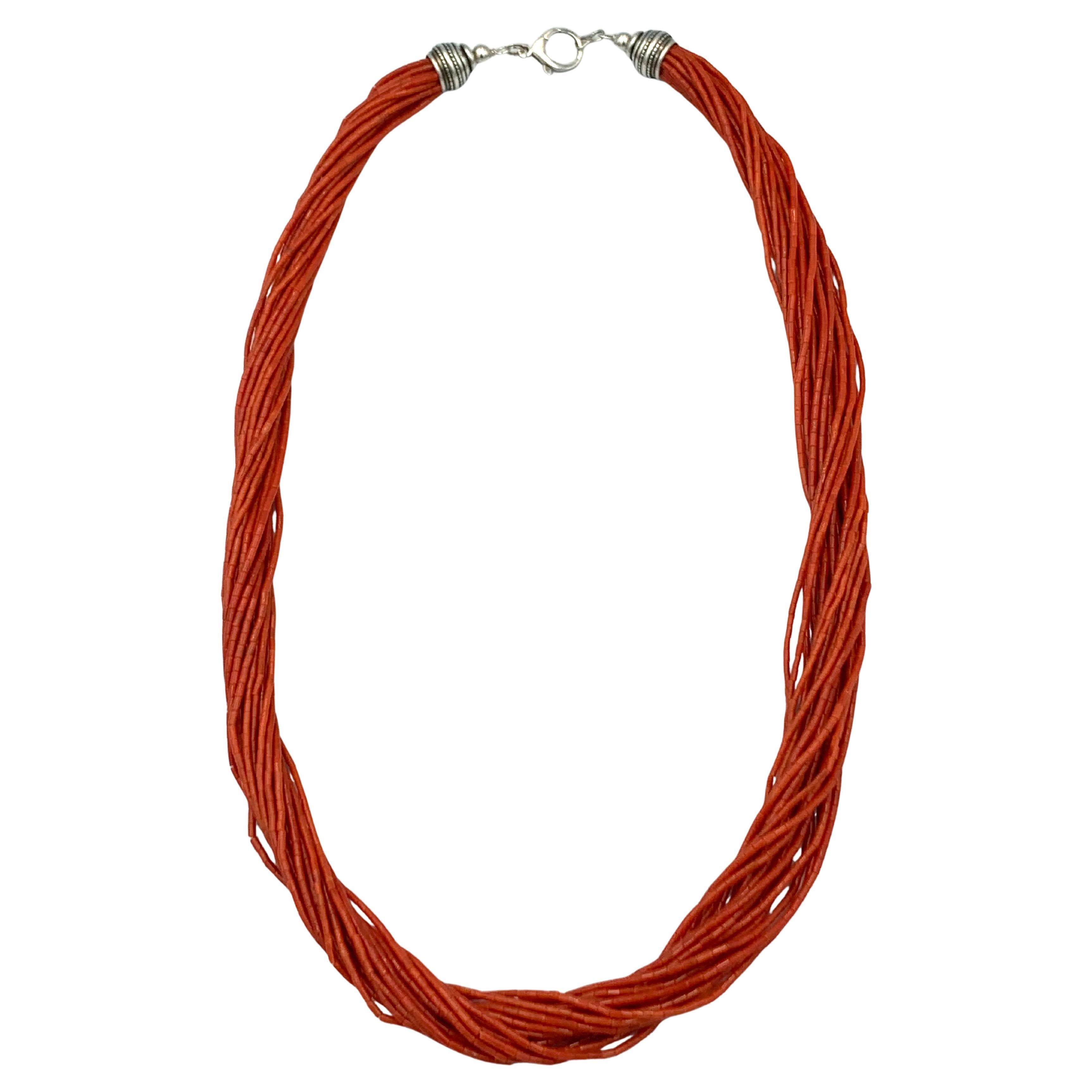 This beautiful necklace has 20 strands of hand rolled tubed natural Mediterranean red coral beads. The 30” necklace has sterling silver ends with a Zia Cross hallmark. 
