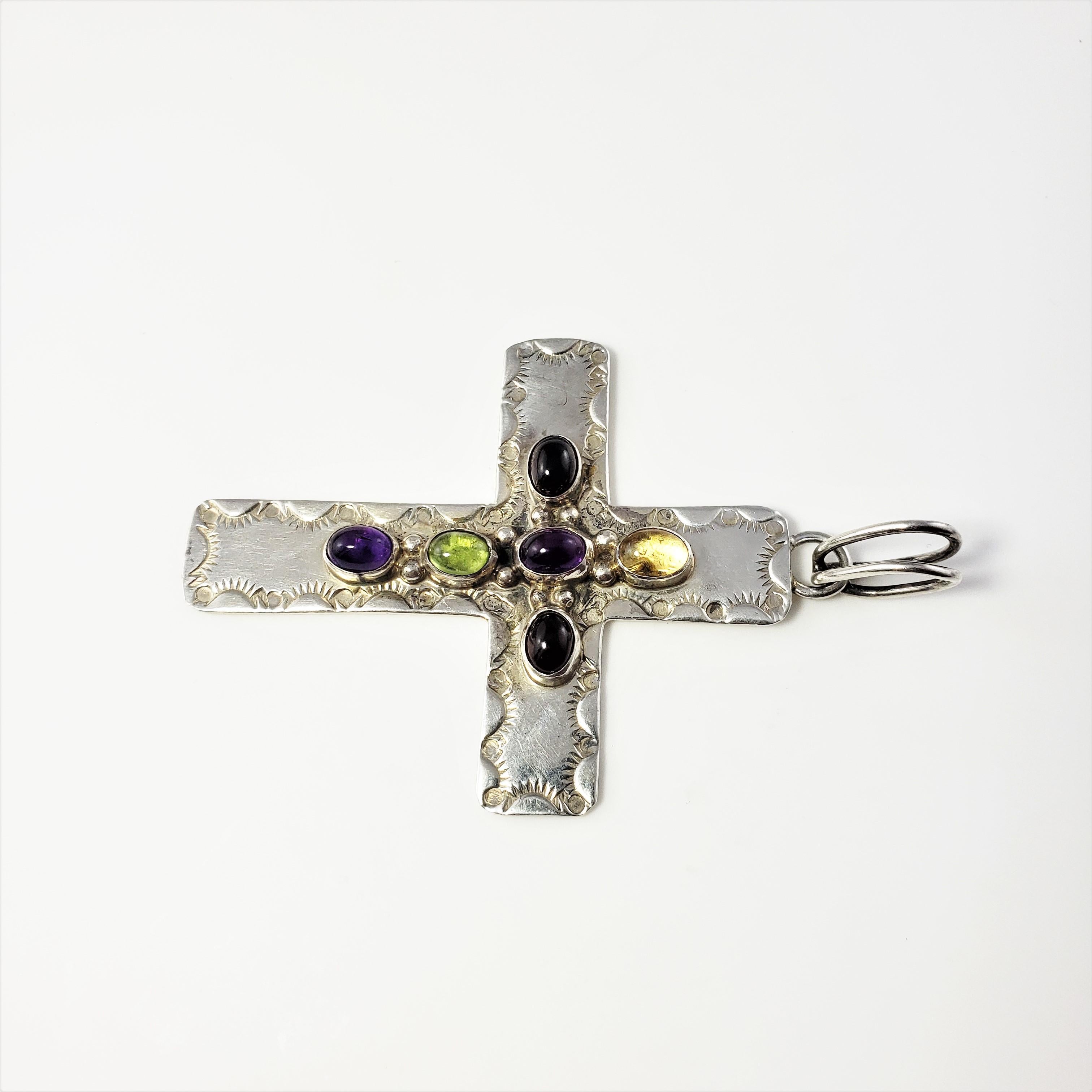 Vintage Native American AC Stamped Sterling Silver Multi-Stone Cross Pendant-

This lovely Native American is decorated with six oval cabochon gemstones* (7 mm x 6 mm each) set in beautifully detailed sterling silver.
*One citrine, one peridot, two