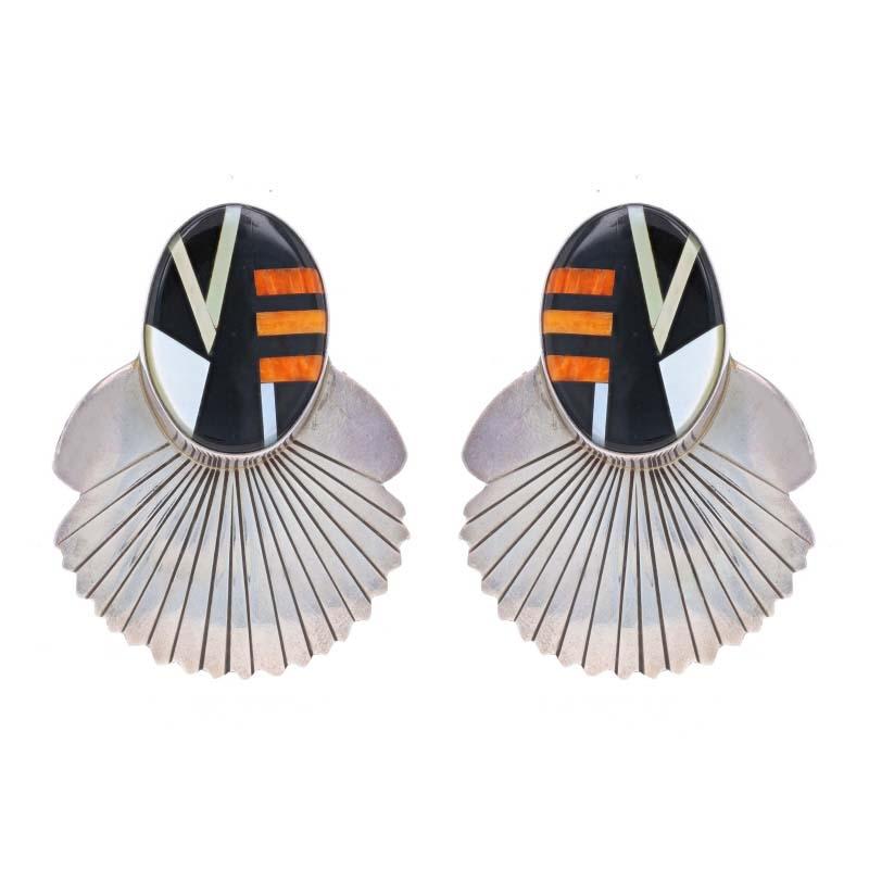 Native American
Artisan: Al Nez
Tribal Affiliation: Navajo

Metal Content: Sterling Silver

Stone Information
Natural Onyx
Color: Black

Natural Mother of Pearl
Color: White & Yellow

Natural Spiny Oyster
Color: Reddish Orange

Style: Large