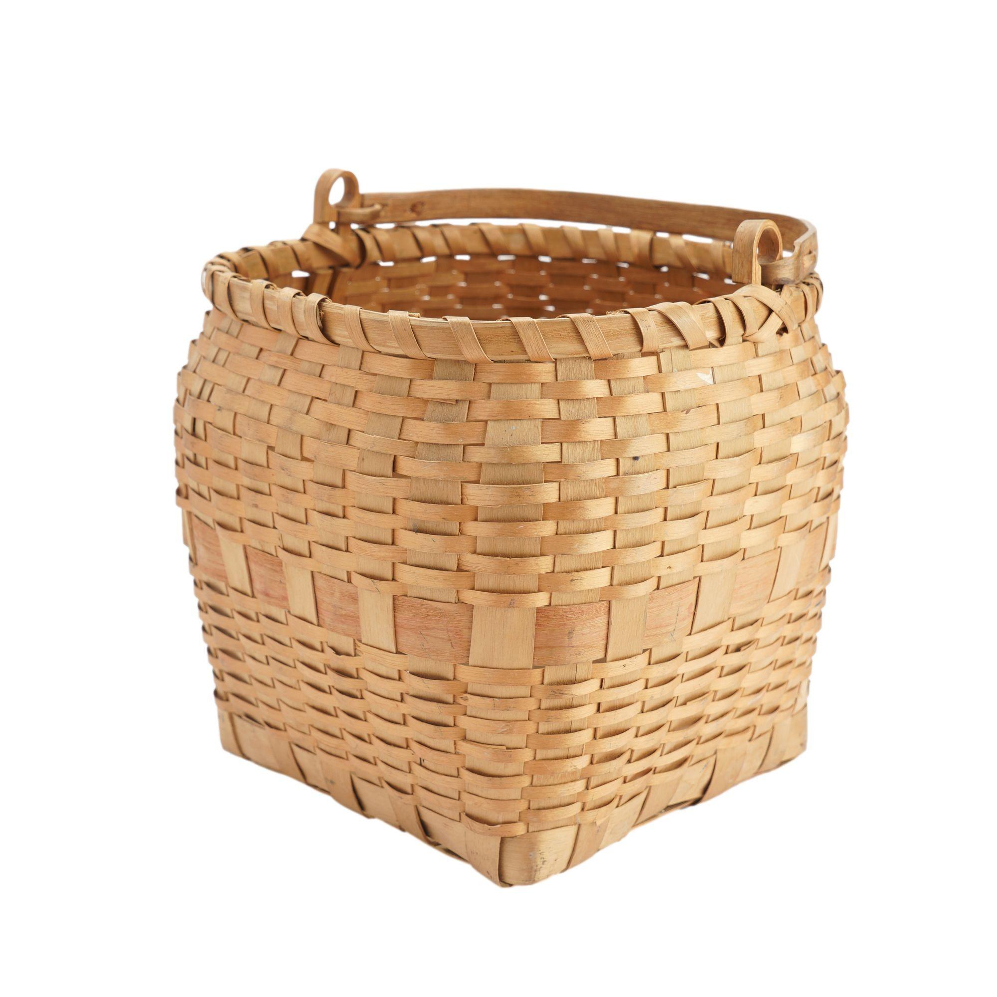 19th century Native American hand woven square based ash basket with a hand carved clothes pin hinged loop handle. The upper rim of the basket is captured by a round double ash spline lashed with 1/4