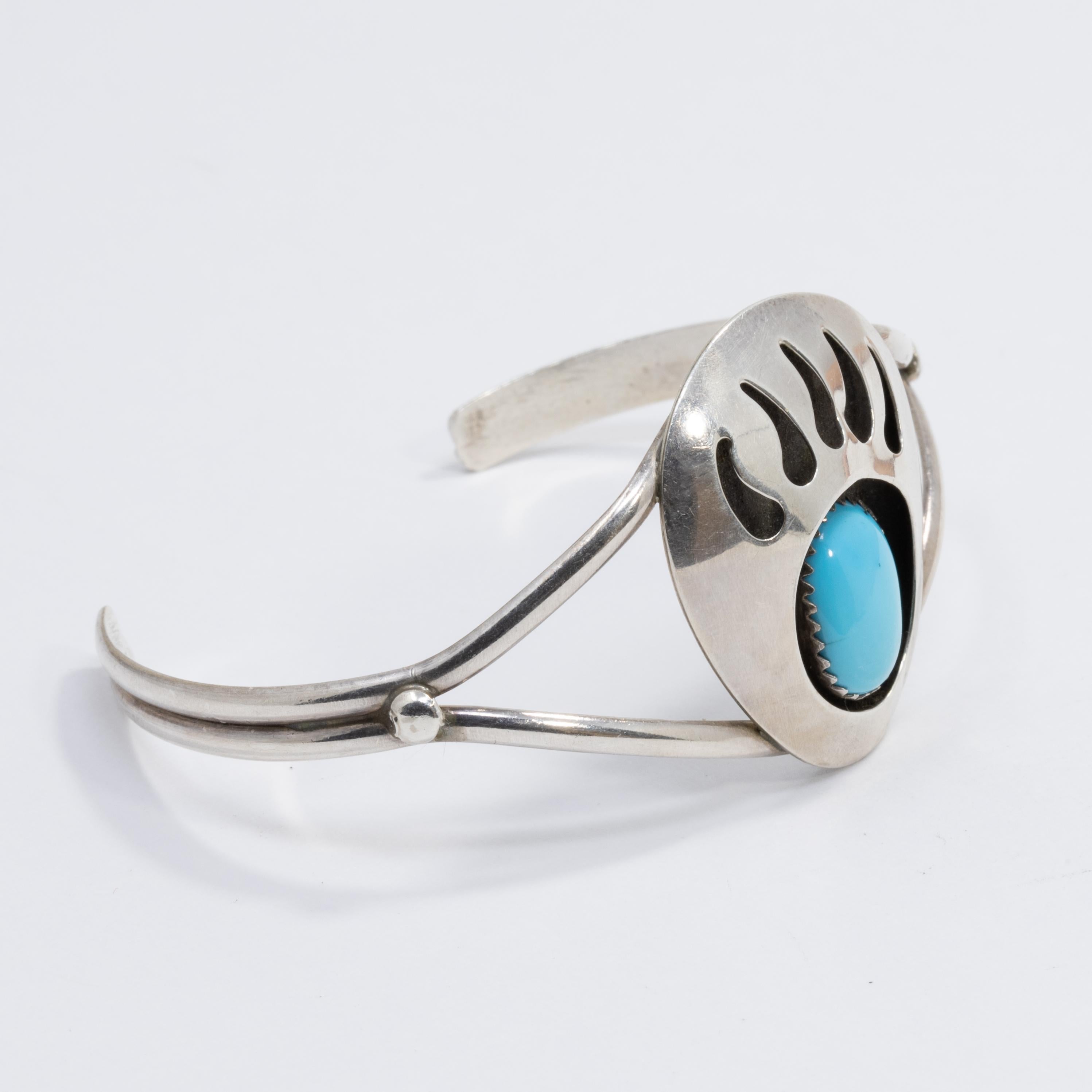 A vintage Native American bracelet! This elegant sterling silver cuff features a bear claw motif centerpiece accented with a single turquoise cabochon, which is set in a sawtooth bezel.

Inner diameter at widest part: 6 cm
Face height: 3.1 cm