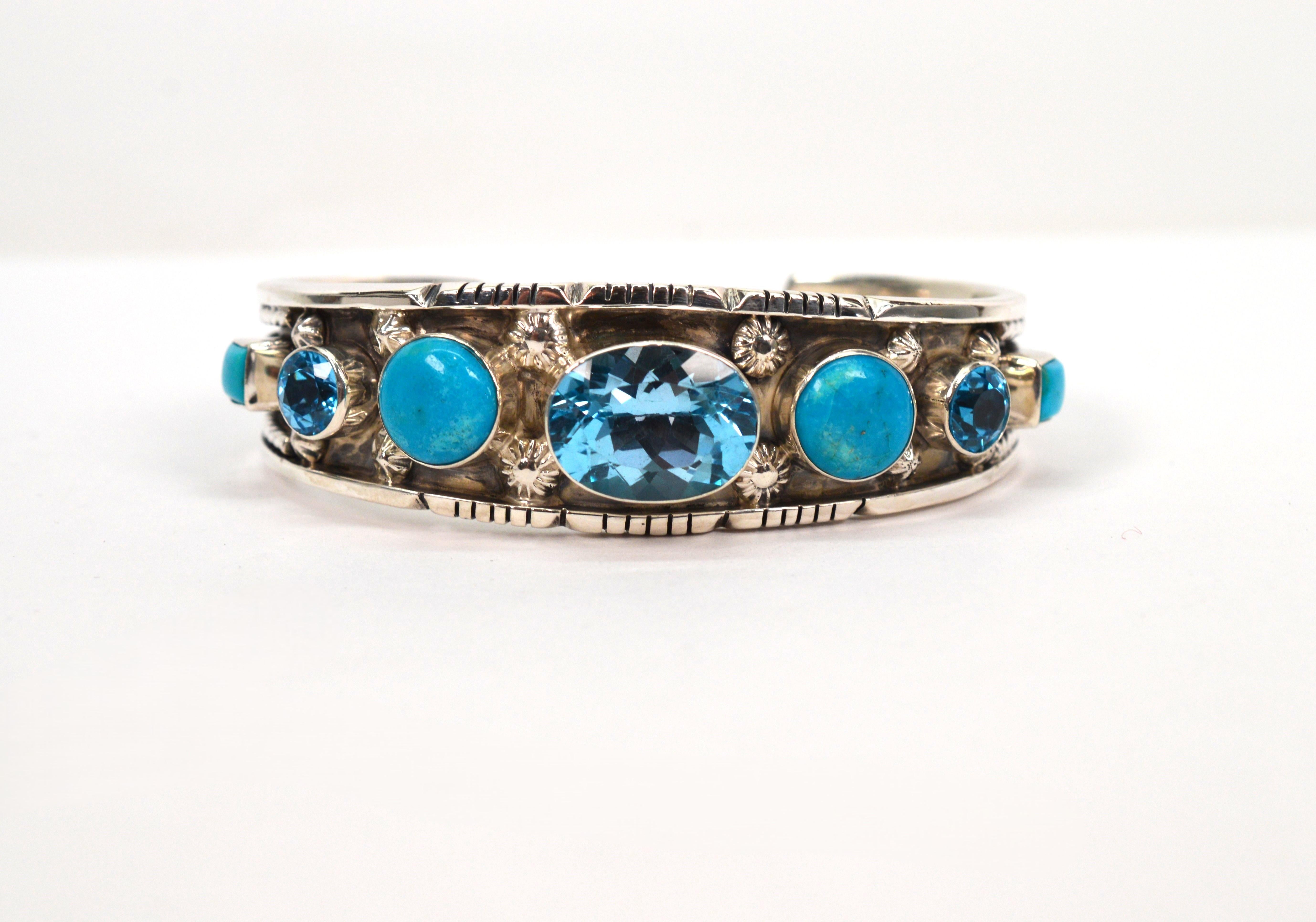 Vivid blue topaz coupled with turquoise display striking color on this silver silver Native American made cuff bracelet.
Hand crafted by Southwest silver artisans, this bracelet is presented by Running Bear Trading Co. 
Utilizing both a combination