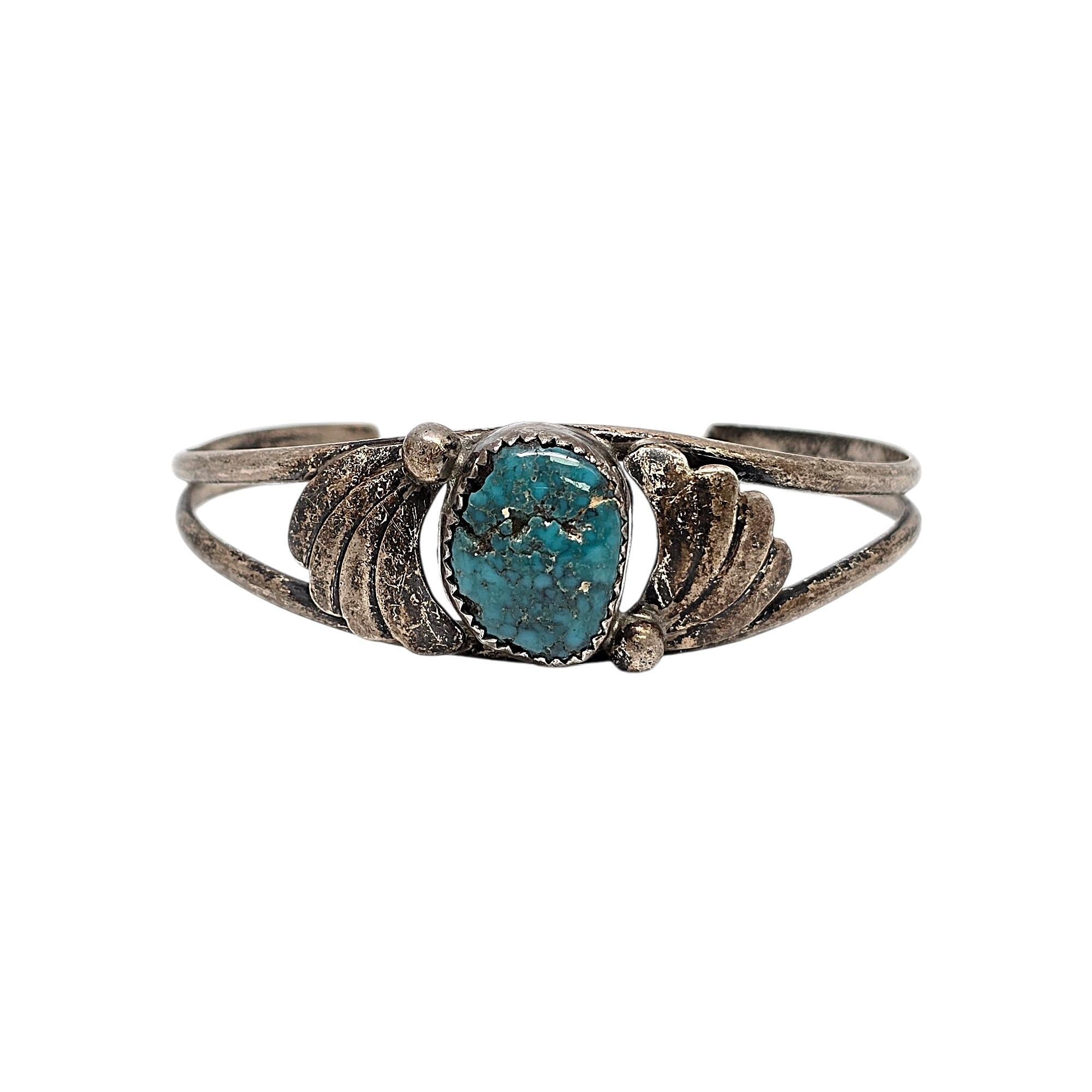Sterling silver and turquoise cuff bracelet by Native American artisan signed Chee.

This bracelet features a turquoise stone in a saw tooth bezel with a small bead accent and swirl design on each side of the stone.

Weighs approx 11.5g,