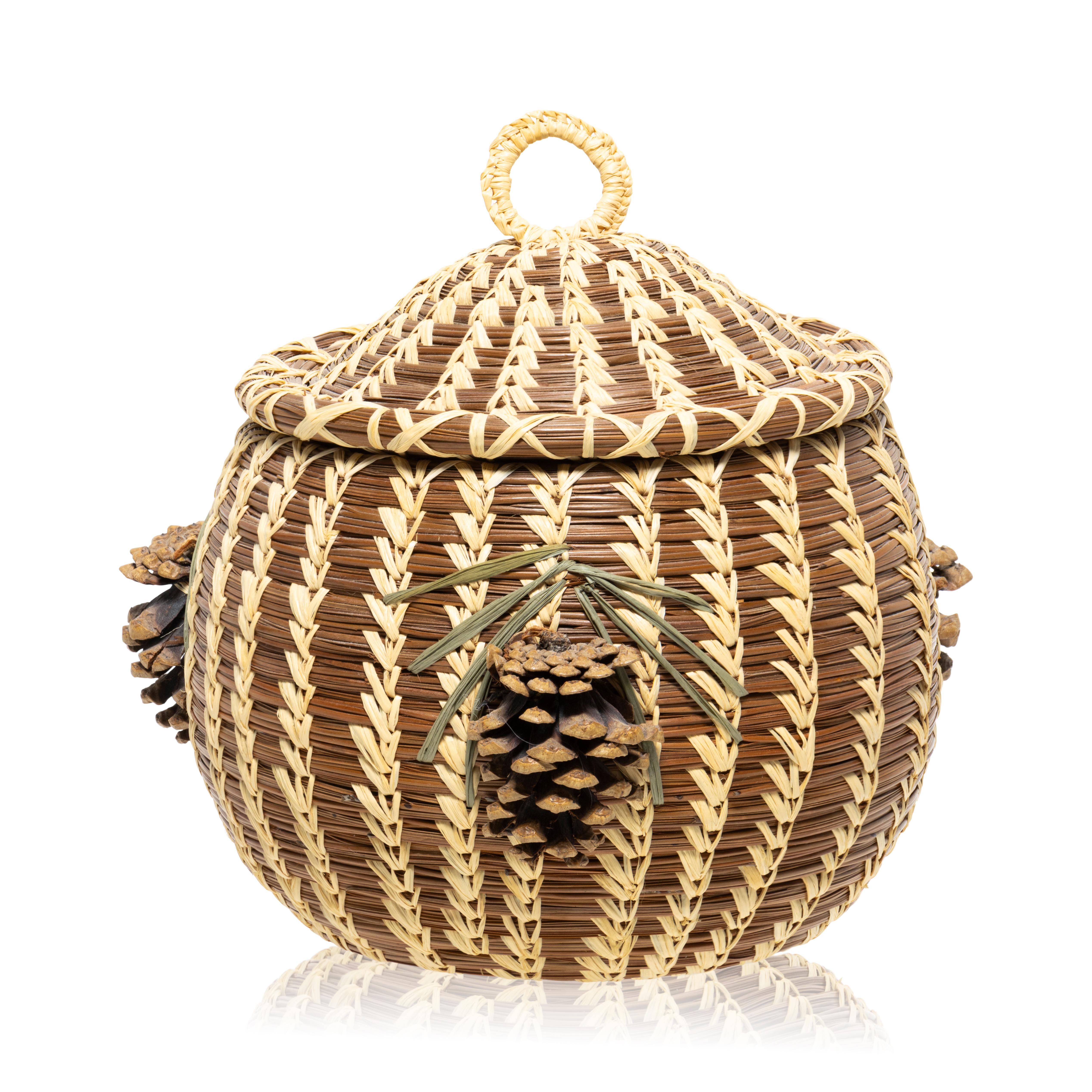 Coushatta lidded pine needle basket with pine cone and needle décor two sides and top. This woven by L.C. John, the last of the great Coushatta basket makers. This basket is made from longleaf pine needles native to the state stitched with raffia