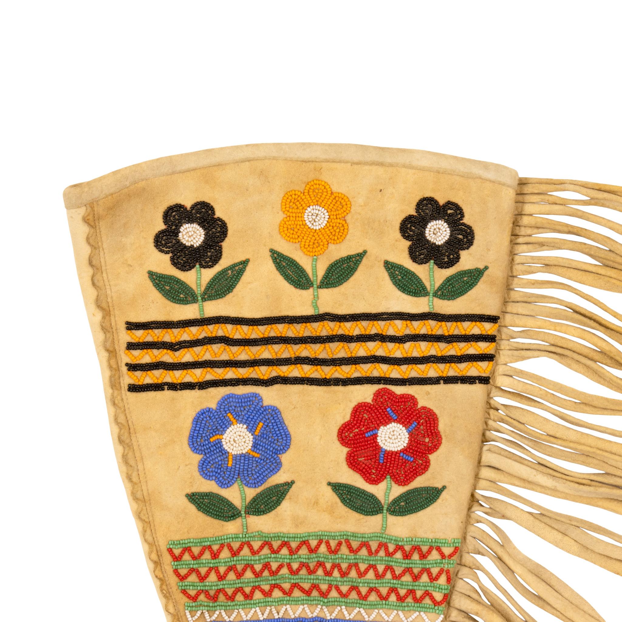 Gran par de guanteletes Cree con cuentas de los nativos americanos. Con cinco flores multicolores y bandas en zigzag en colores rojo, amarillo, negro, azul, verde y blanco. 18