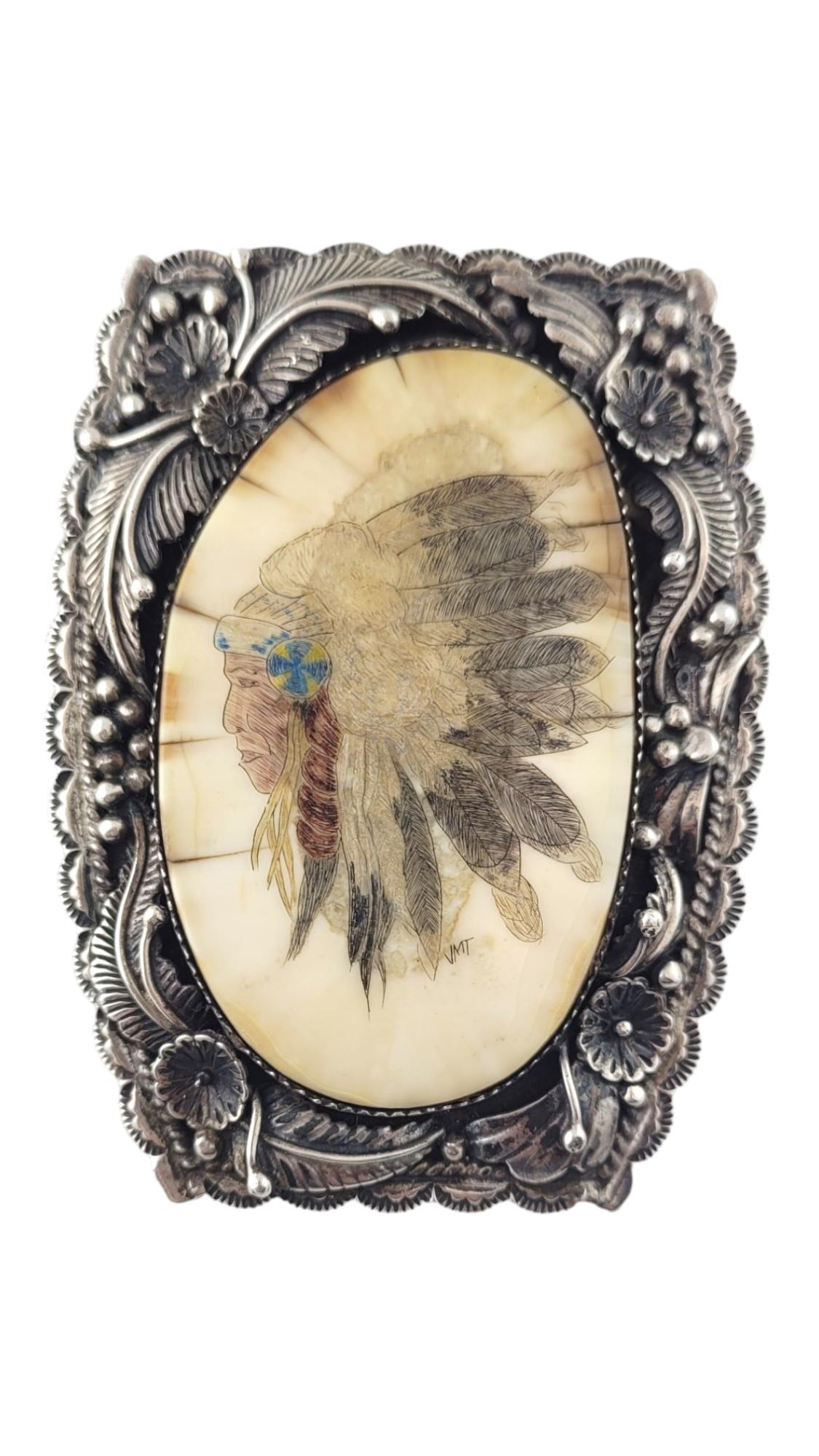 Native American D Delgarito Chief Head Sterling Silver Bolo Pendant w/ Tips

This bolo features a large white stone with a Native American Chief painted on it. Art is signed JMT. Sterling silver frame features flower, leaf and mead design with