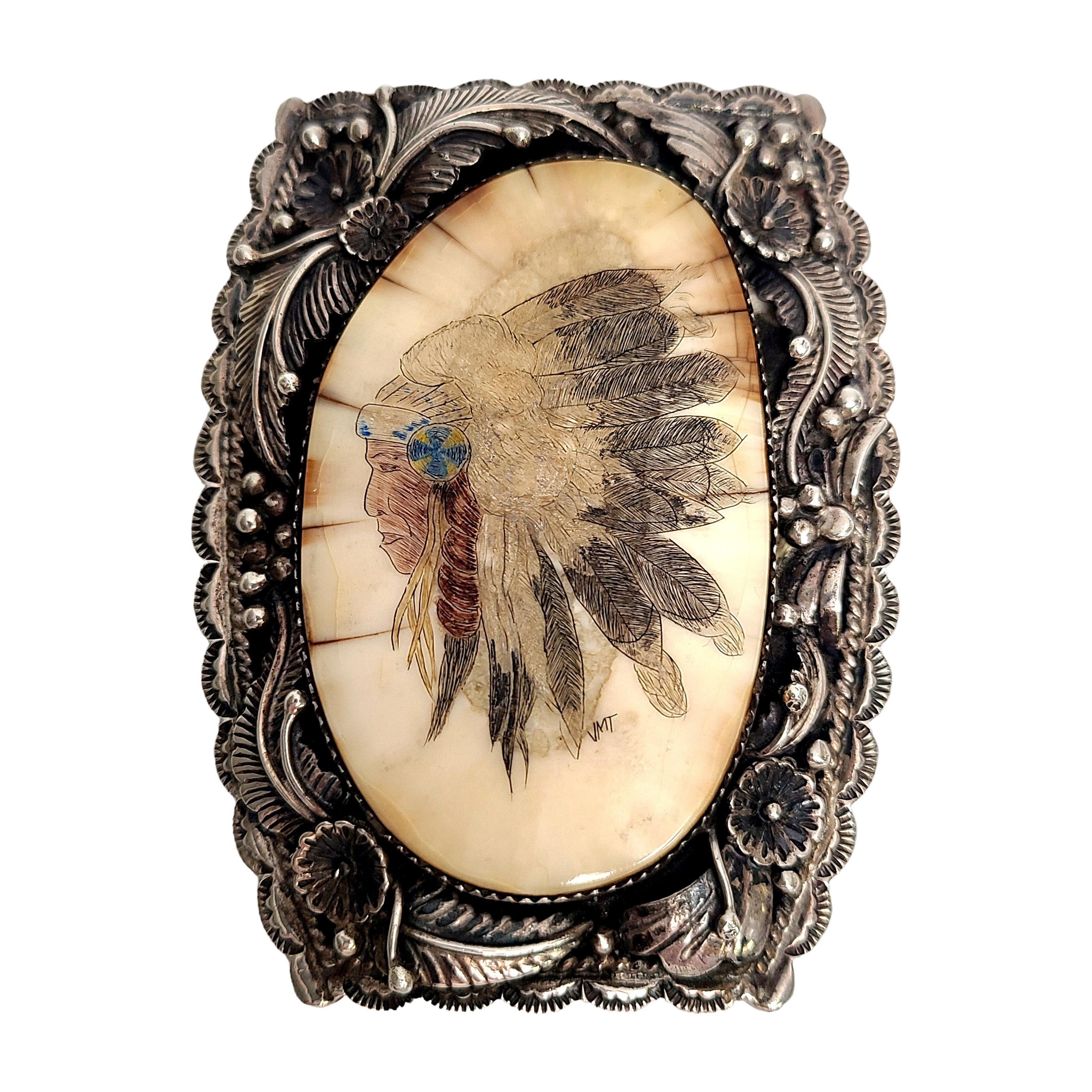 Sterling silver and white stone bolo pendant and tips by Native American artisan, Delbert Delgaritro.

This bolo features a large white stone with a Native American Chief painted  on it. Art is signed JMT. Sterling silver frame features flower, leaf