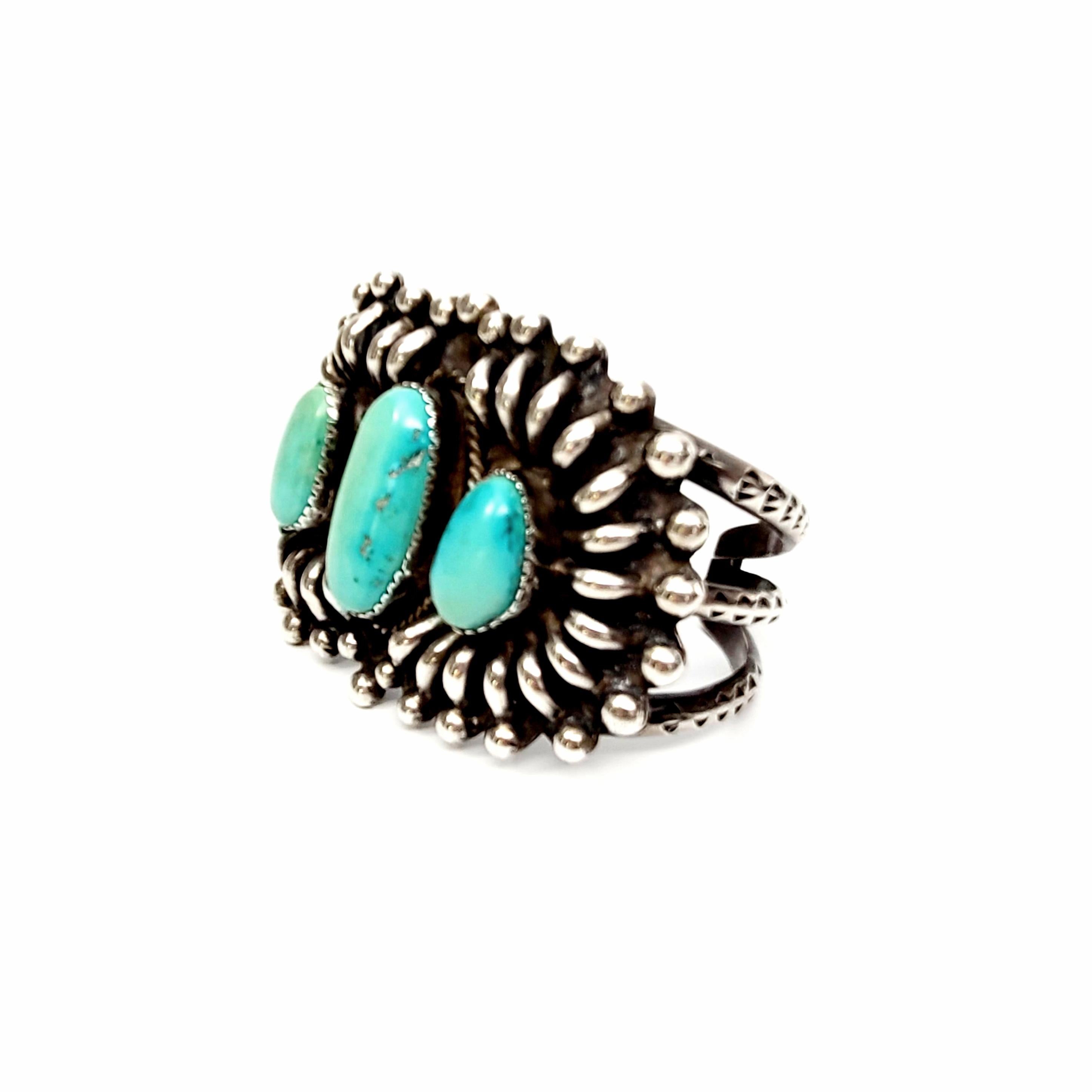 Sterling silver and turquoise cuff bracelet by Native American artisan, Daisy M Tsosie.

Gorgeous large cuff bracelet featuring 3 saw-tooth bezel set turquoise stones with rope texture accents and beautiful metalwork around the stone.

Measures