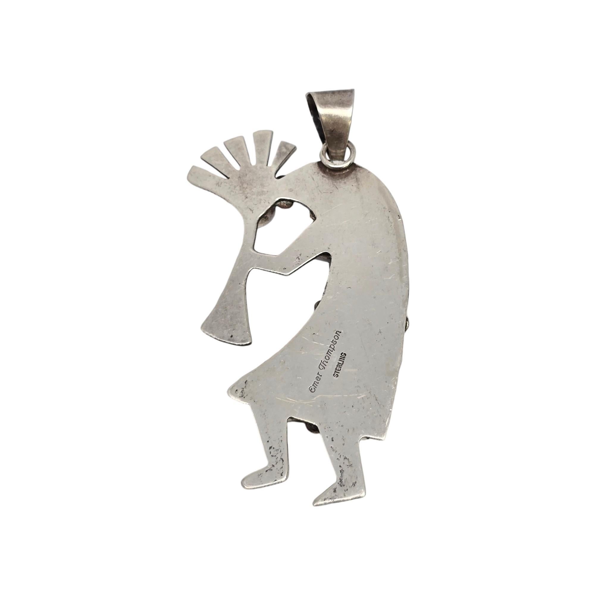Sterling silver and multi-stone Kokopelli pendant by Native American Navajo artisan Emer Thompson.

The kokopelli is said to bring good luck and prosperity. This pendant features bezel set stones that appear to be mother of pearl, onyx, coral and