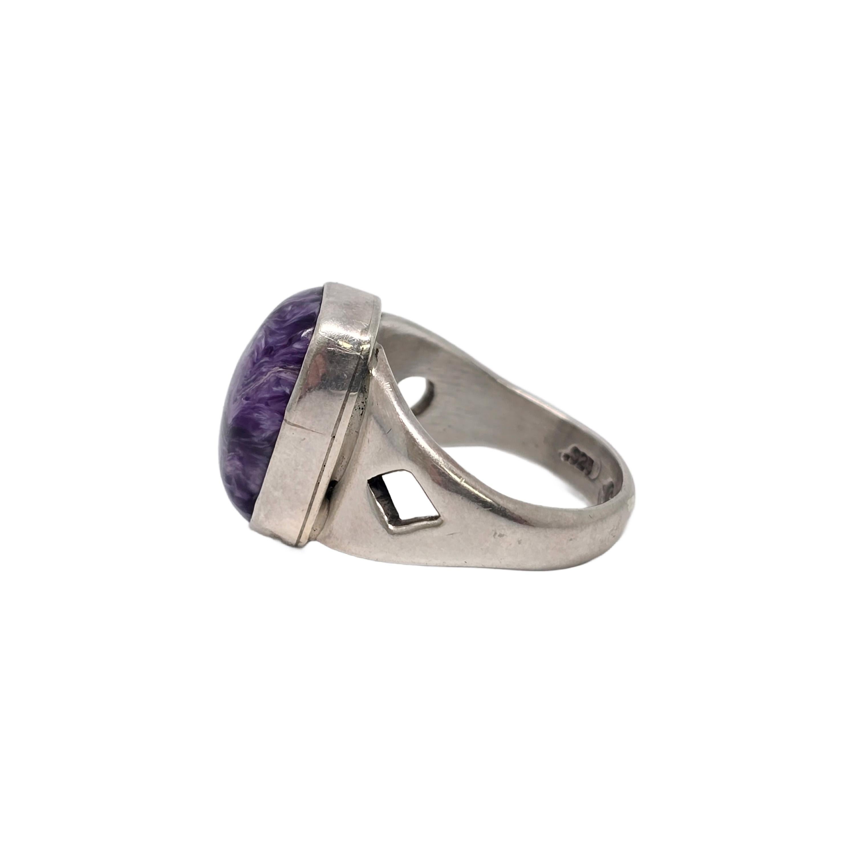 Sterling silver and charoite ring by Native American Navajo artisan Frederick Chavez.

Size 7 1/4

Beautifully veined purple charoite is bezel set with cut-out designs on each shoulder.

Weighs approx 8.5g, 5.4dwt

Measures approx 5/8