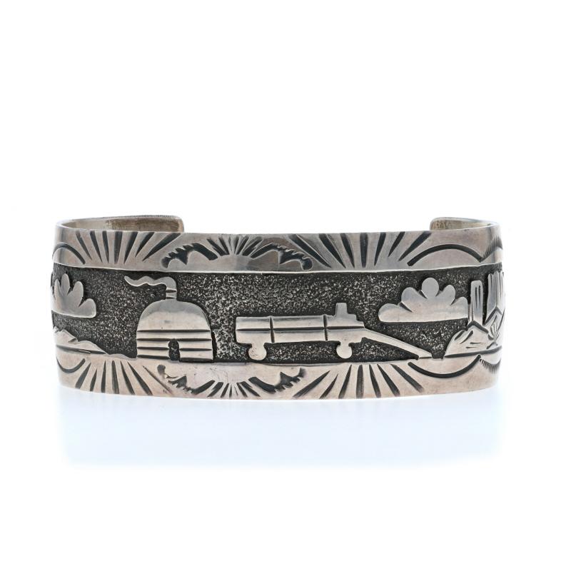 Design:  Bracciale Storyteller
Nativi americani
Artigiano: Gibson & Gibson
Affiliazione tribale: Navajo

Contenuto del metallo: Argento Sterling

Stile del bracciale: Bracciale
Tipo di chiusura: N/A (scivola sul polso)
Tema: Paesaggio della