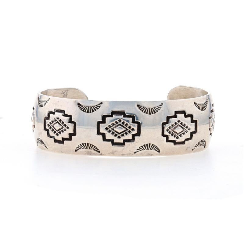 Native American
Artisan: Harry R. Morgan
Tribal Affiliation: Navajo

Metal Content: Sterling Silver

Style: Cuff
Fastening Type: N/A (slides over wrist)
Features: Etched Detailing

Measurements
Inner circumference (including the opening): 6