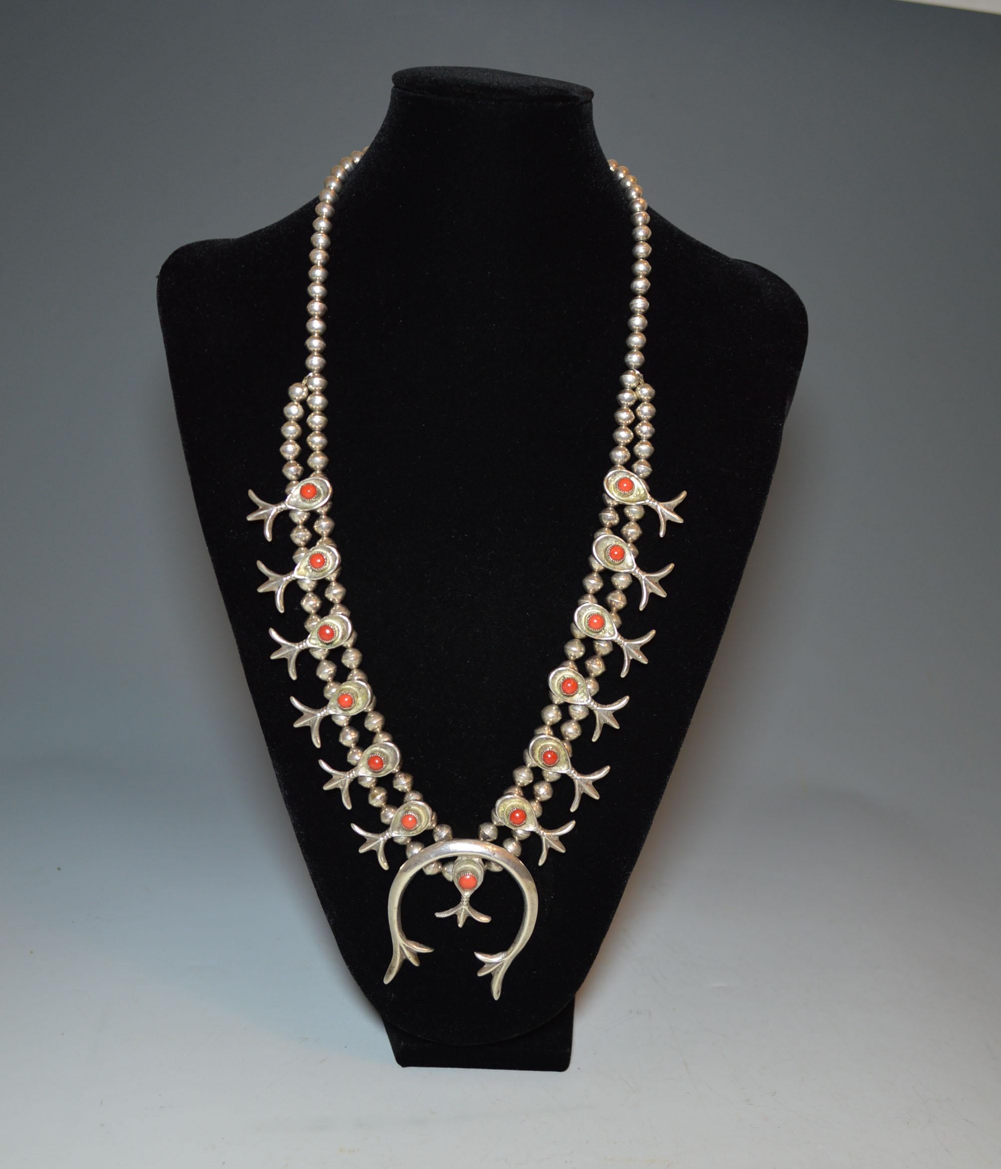 A fine vintage Native American Navajo silver and coral squash blossom necklace
Classic Navajo sterling silver squash blossom design with coral inlay
Unmarked
Size: 27 inches, 69 cm all way round, 
Period: 1950s-1960s


Size 10.5 x 9.5 cm, 4