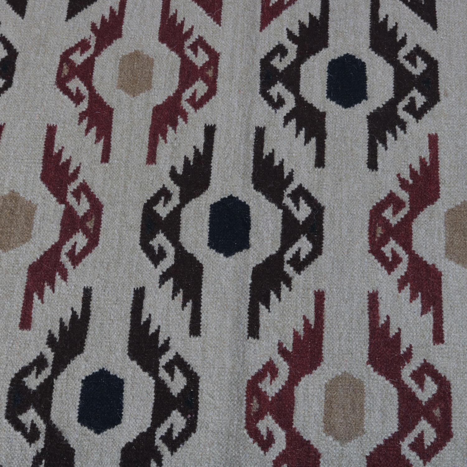 A Native American Indian Navajo style area rug features repeating central geometric design of stylized eagles in beige, maroon red, deep brown, yellow, black and tan, 20th century.

***DELIVERY NOTICE – Due to COVID-19 we are employing NO-CONTACT