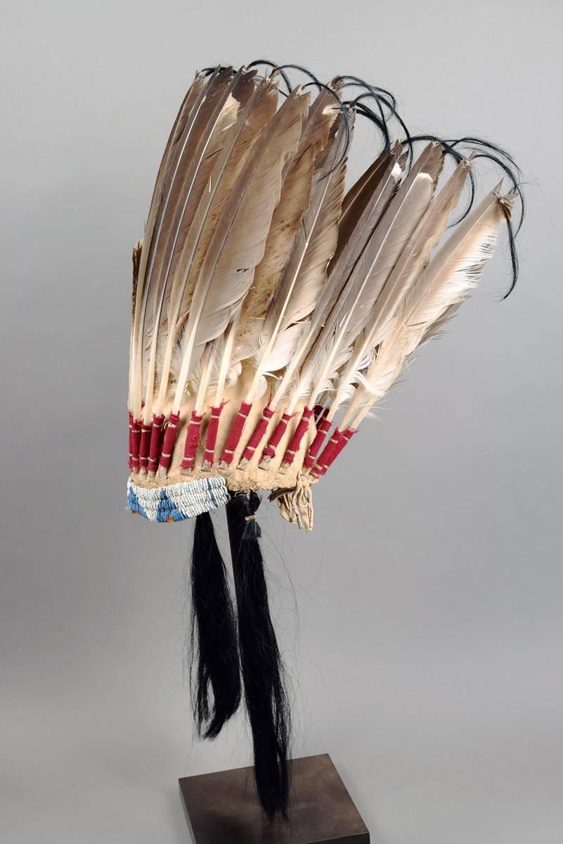 A fine Native American Sioux Plains Indian beaded feather war bonnet.

The bead work Sinew beaded on buck skin, with wool trade cloth and human hair from a old UK collection.

Period: last quarter of the 19th century.

Condition: