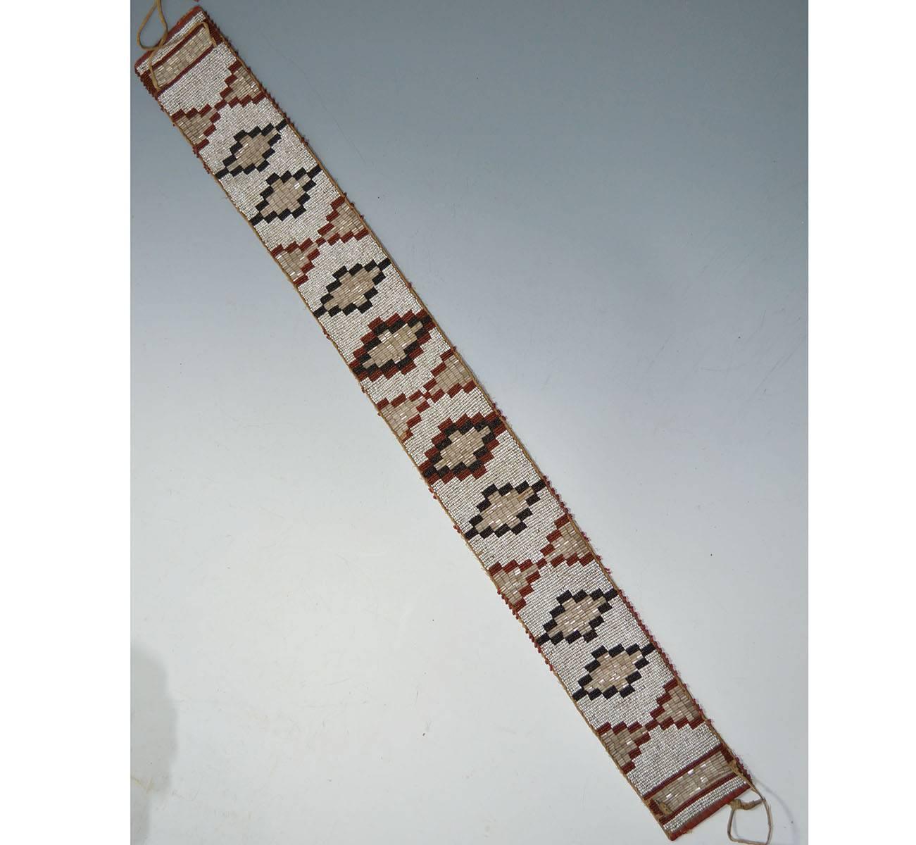 Native American Indian rare blackfoot beaded belt
A very fine and rare old belt in geometric pattern with the inclusion of long tubular beads
Cloth backed with buck skin fasteners
Very fine bead work in excellent condition.
Period: Last quarter