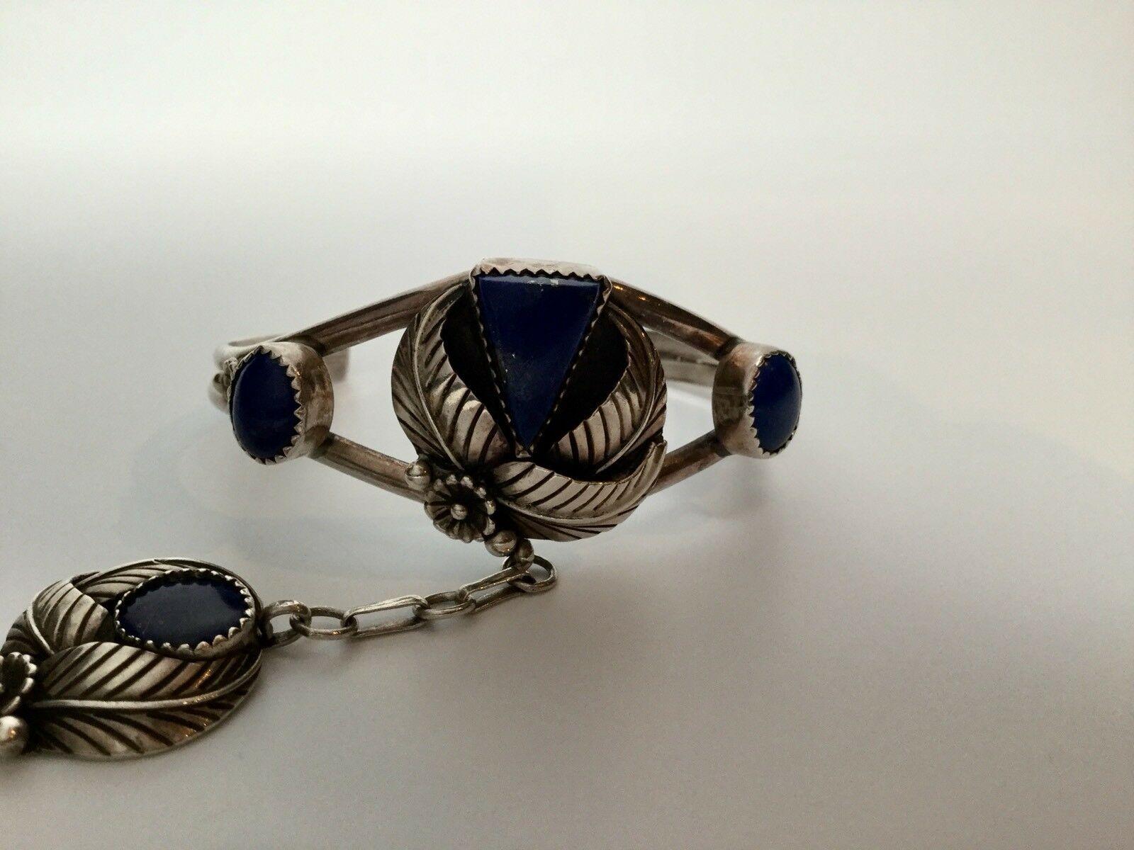 Native American Lapis Slave Bracelet

Marked: Sterling
Signed: W

Measurements:
Cuff:
5 1/4” end to end
~2 7/16” wide
widest end: ~1”
narrowest end: 1/4”

Stones:
9 mm x 7mm
10 mm x 7 mm
Triangle stone: 15 mm x 10 mm

Middle Pendant:
23 mm x 20