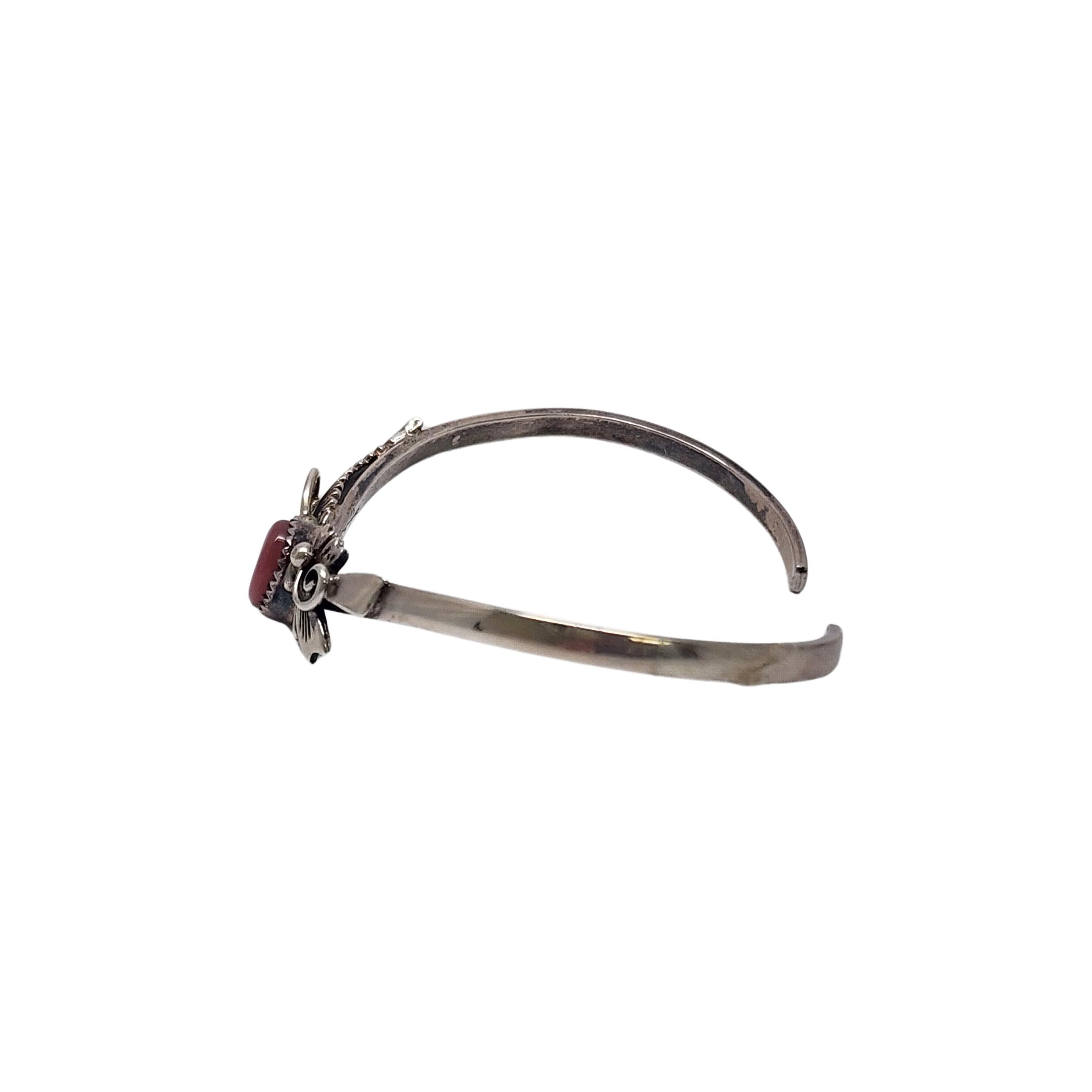 Sterling silver pink mother of pearl cuff bracelet by Native American artisan Les Baker and GS.

Beautifully delicate thin V shaped bracelet with a small pink mother of pearl in a sawtooth bezel. Sterling Silver applied flowers and a feather flank