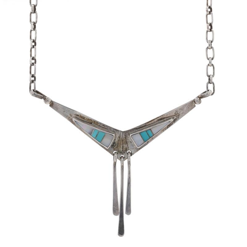 Native American
Artisan: LLL

Metal Content: Sterling Silver

Stone Information
Natural Mother of Pearl
Cut: Inlay
Color: White

Natural Turquoise
Treatment: Routinely Enhanced
Cut: Inlay
Color: Greenish Blue

Chain Style: Long & Short 
Fastening: