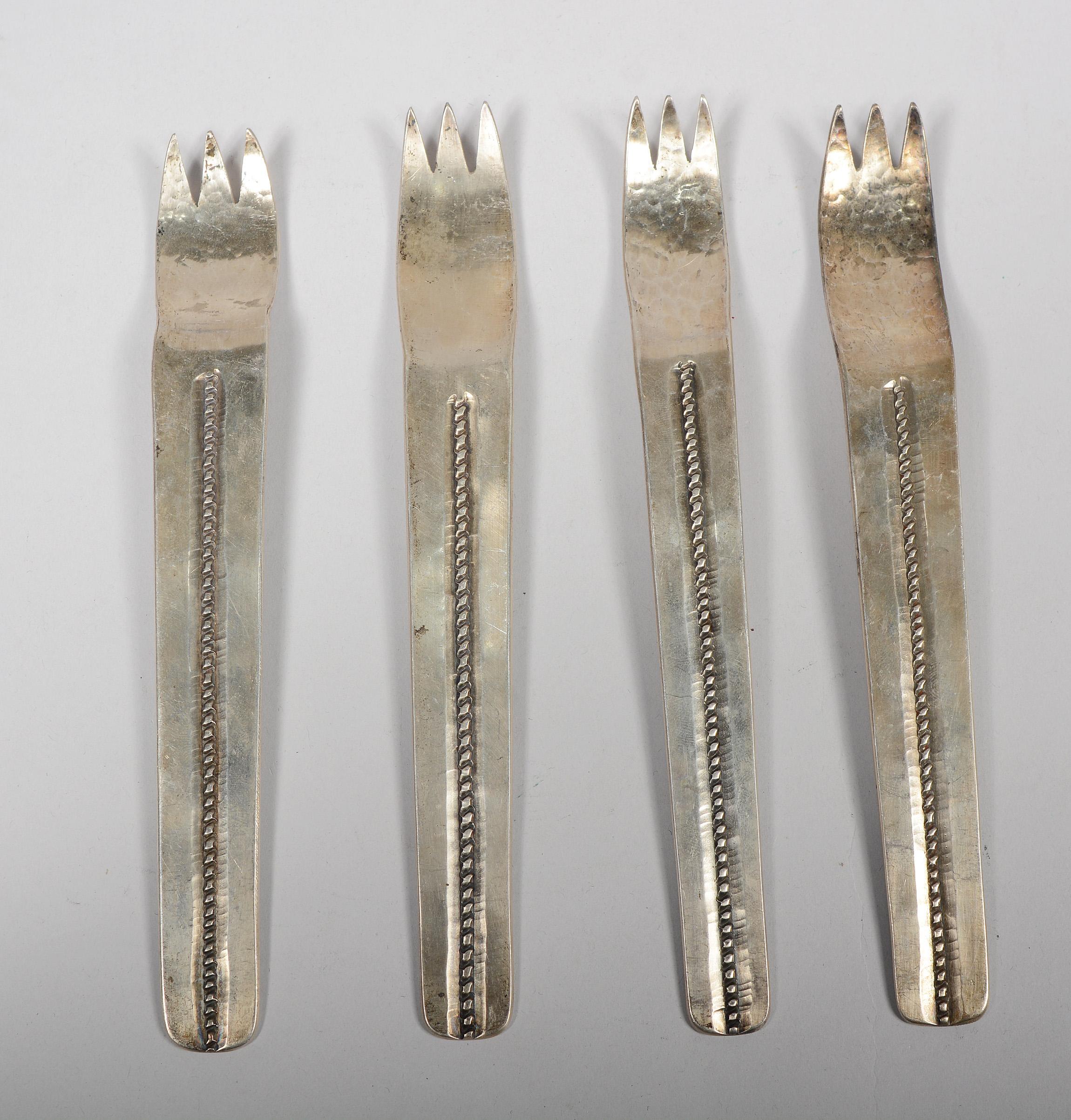 Handmade modernist silver flatware set by a Navajo artist. The pieces are signed but we have been unable to determine the maker. This set includes four three piece place settings and a serving spoon and fork. The forks and spoons have variances in