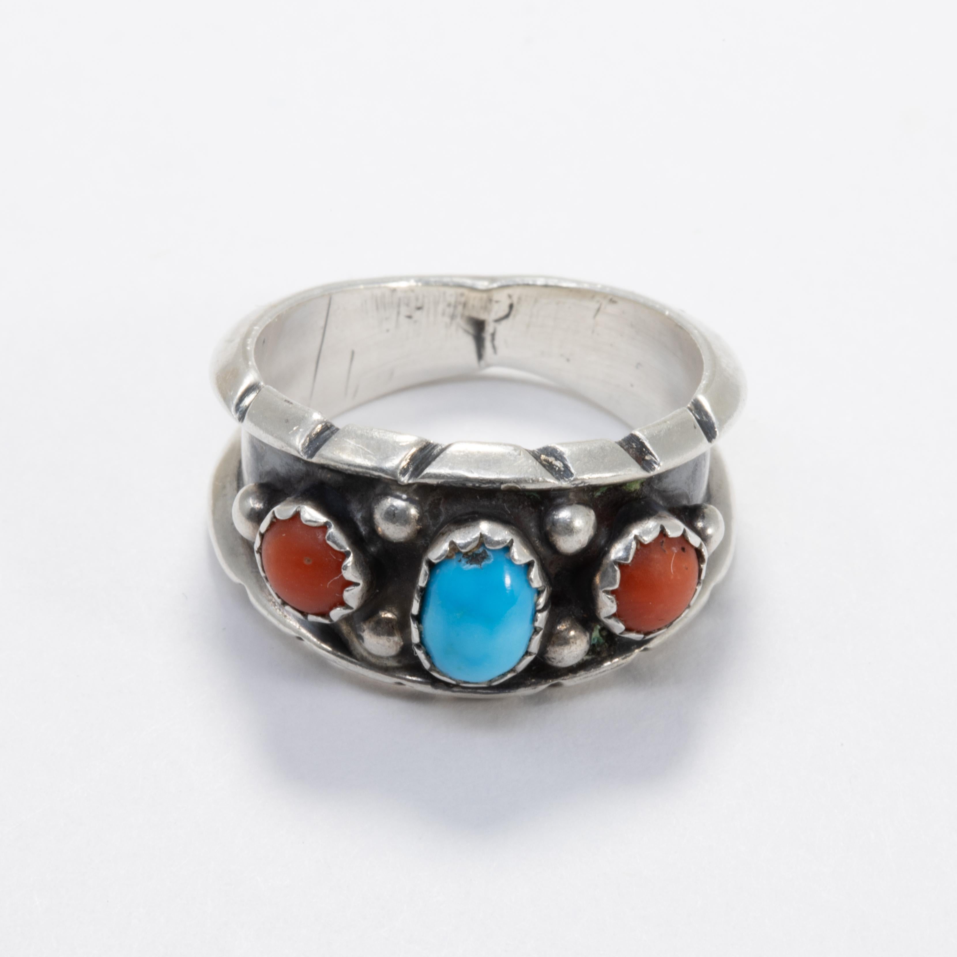 An exquisitely craft Native American Navajo tribe ring. This tapered sterling silver band features coral and turquoise cabochons set in sawtooth bezels. A stylish accessory!

Hallmarks: N1, bear paw motif
Ring size US 7.25