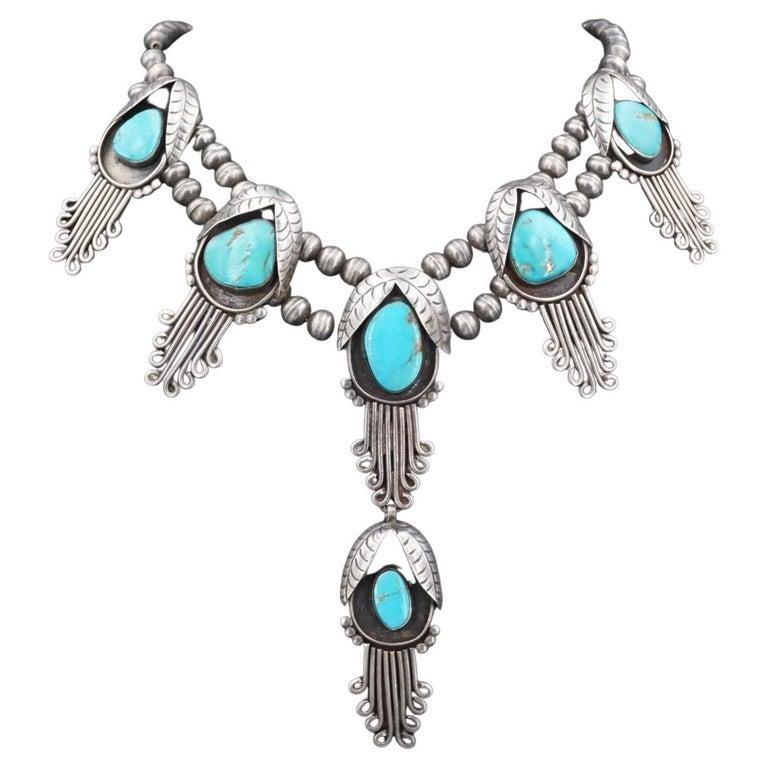Simply Beautiful! Highly Desirable Native American Original Navajo Squash Blossom Necklace. A unique take on the traditional Squash Blossom necklaces, with elongated modern blossoms shaped like gusts of wind. Measuring approx. 29” long; Center