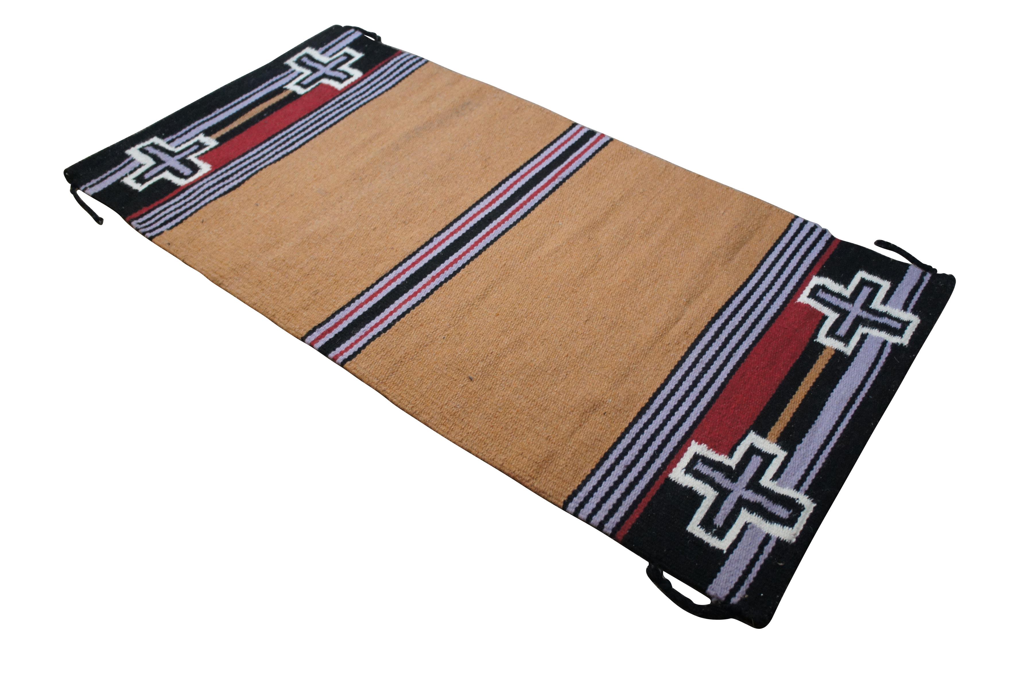 Vintage Native American / Navajo / Southwestern / Western / style hand woven wool saddle blanket / area rug / mat. Camel brown with stripes of black, red, white, and light purple, ends embellished with four crosses.

Dimensions:
65