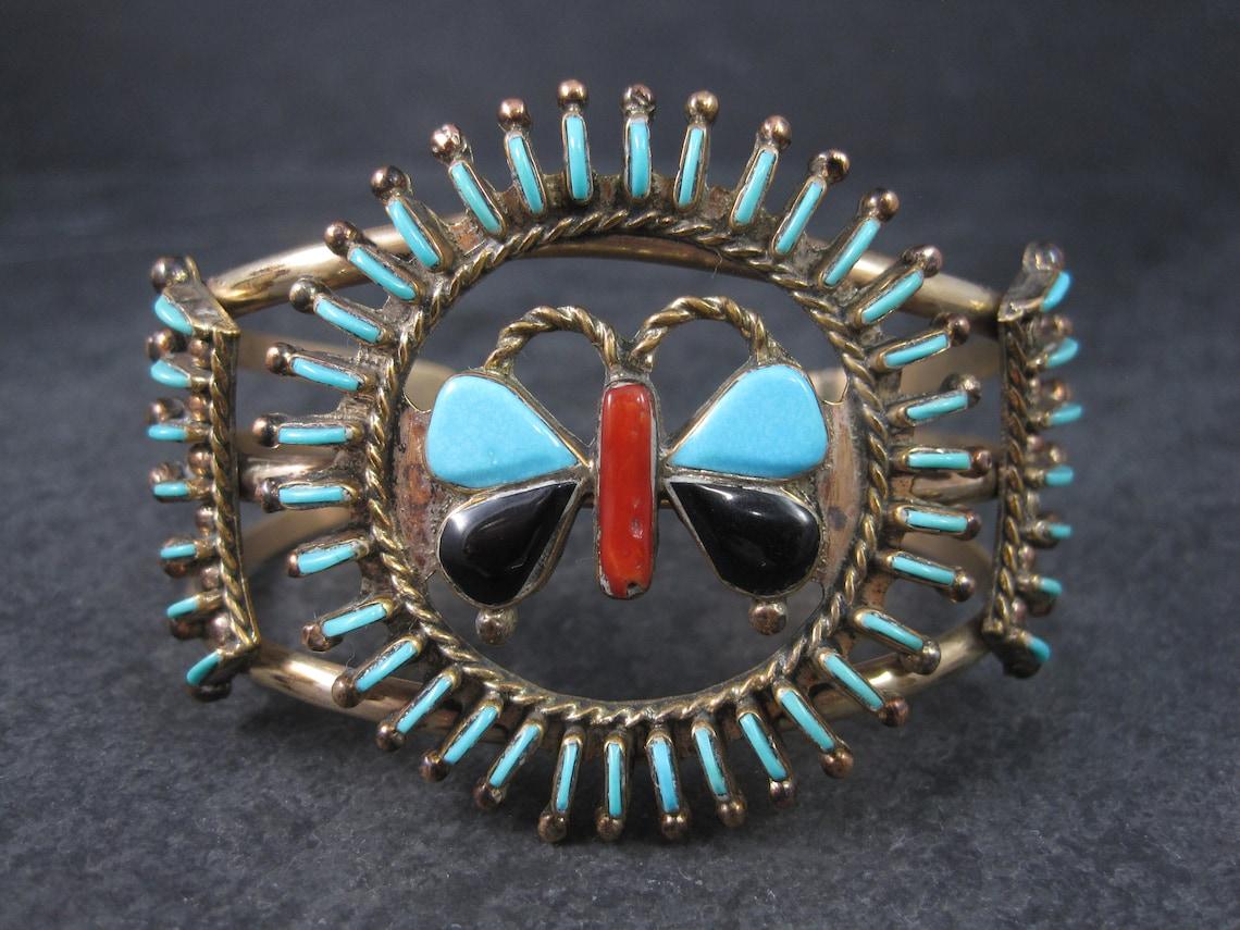 This gorgeous vintage cuff bracelet is gold filled with natural turquoise, onyx and coral gemstones.

It is the creation of Laguna Pueblo artist Paul Lucario Jr.

The face of this bracelet measures 1 13/16 inches north to south.
It has an inner