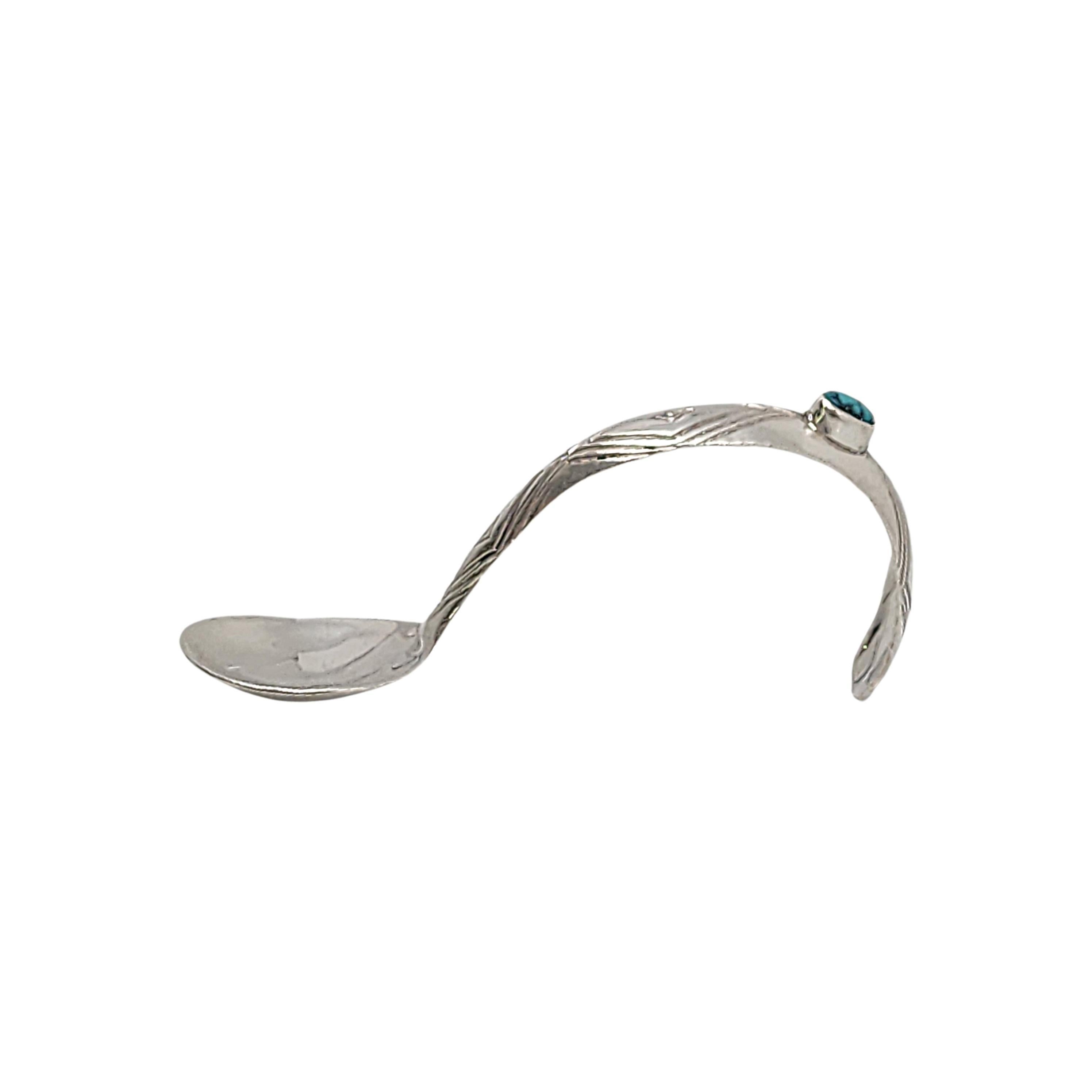 Sterling silver and turquoise baby spoon by Native American Navajo artisan, Patrick Yellowhorse.

This spoon's arched handle features an oval bezel set turquoise with etched concentric diamond design.

Measures approx 3 1/4