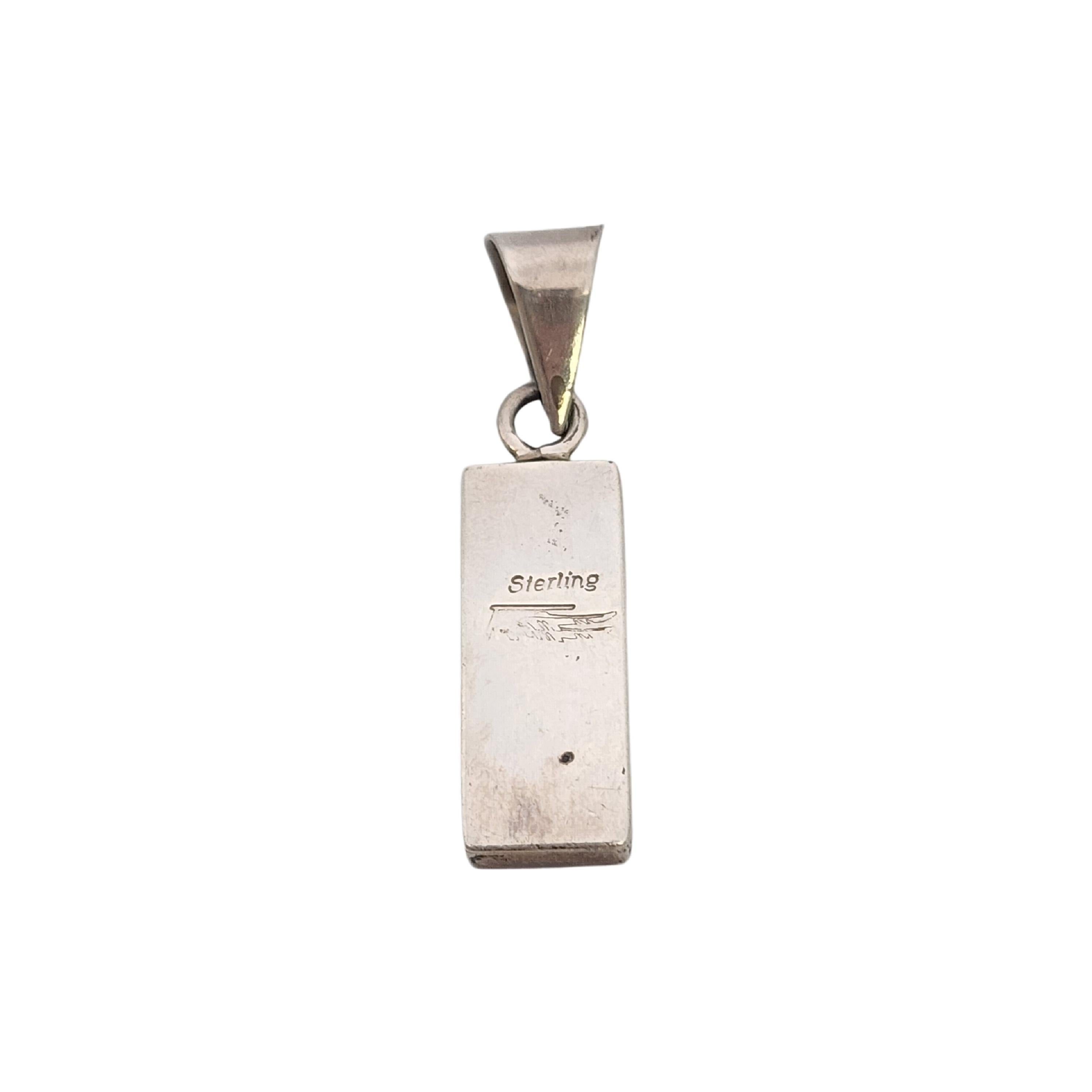 Ciondolo a intarsio in argento sterling dell'artigiano nativo americano Ray Tracey Knifewing.

Questo bellissimo ciondolo presenta un intarsio di turchesi blu scuro, blu chiaro e viola. La pietra blu più scura è splendidamente venata.

Pesa circa