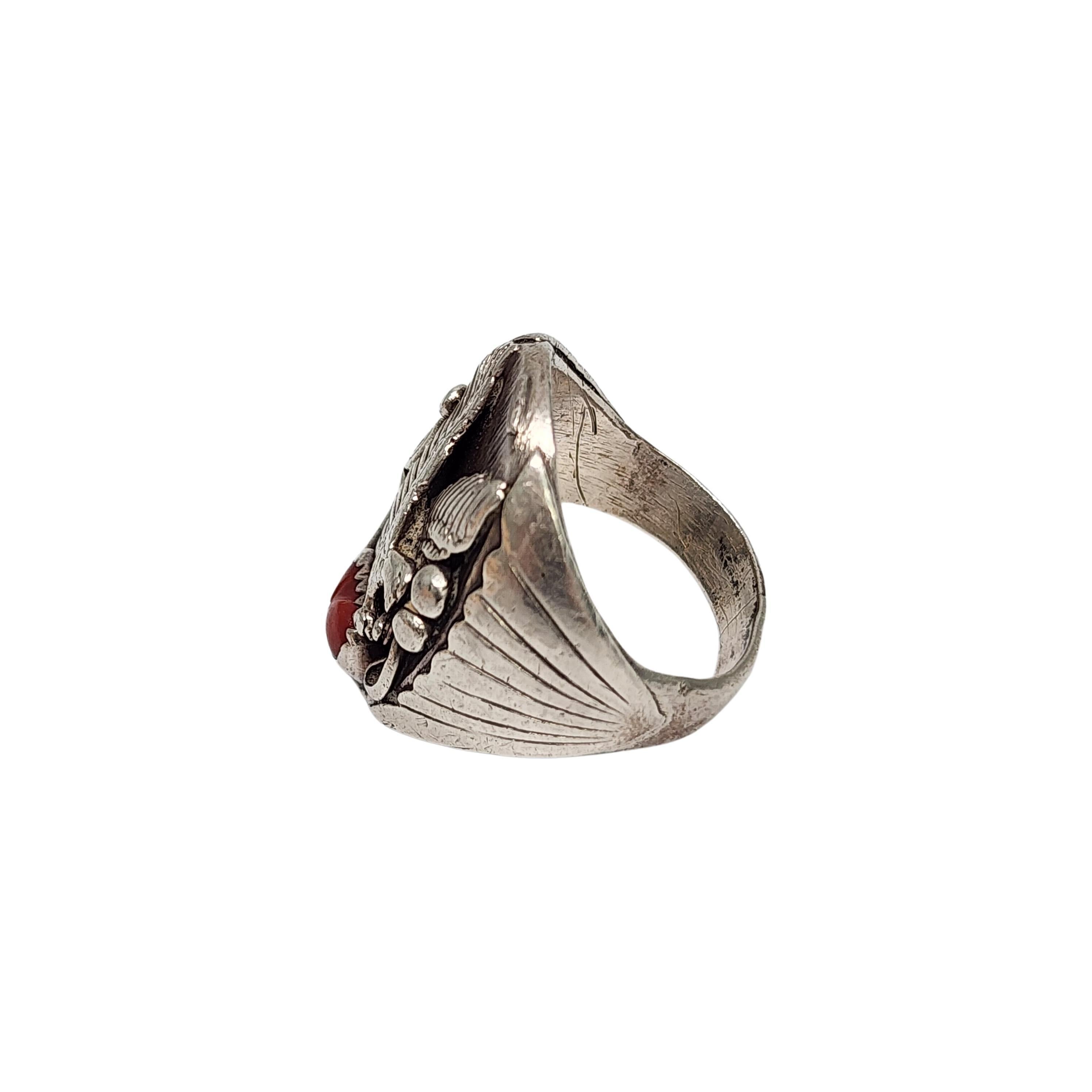 Sterling silver and coral ring by Native American artisan Richard Begay.

Size 10 1/2

This sterling silver ring features a flying eagle with a red coral stone in a saw tooth bezel setting.

Weighs approx 20.3g, 13.0dwt

1 1/8