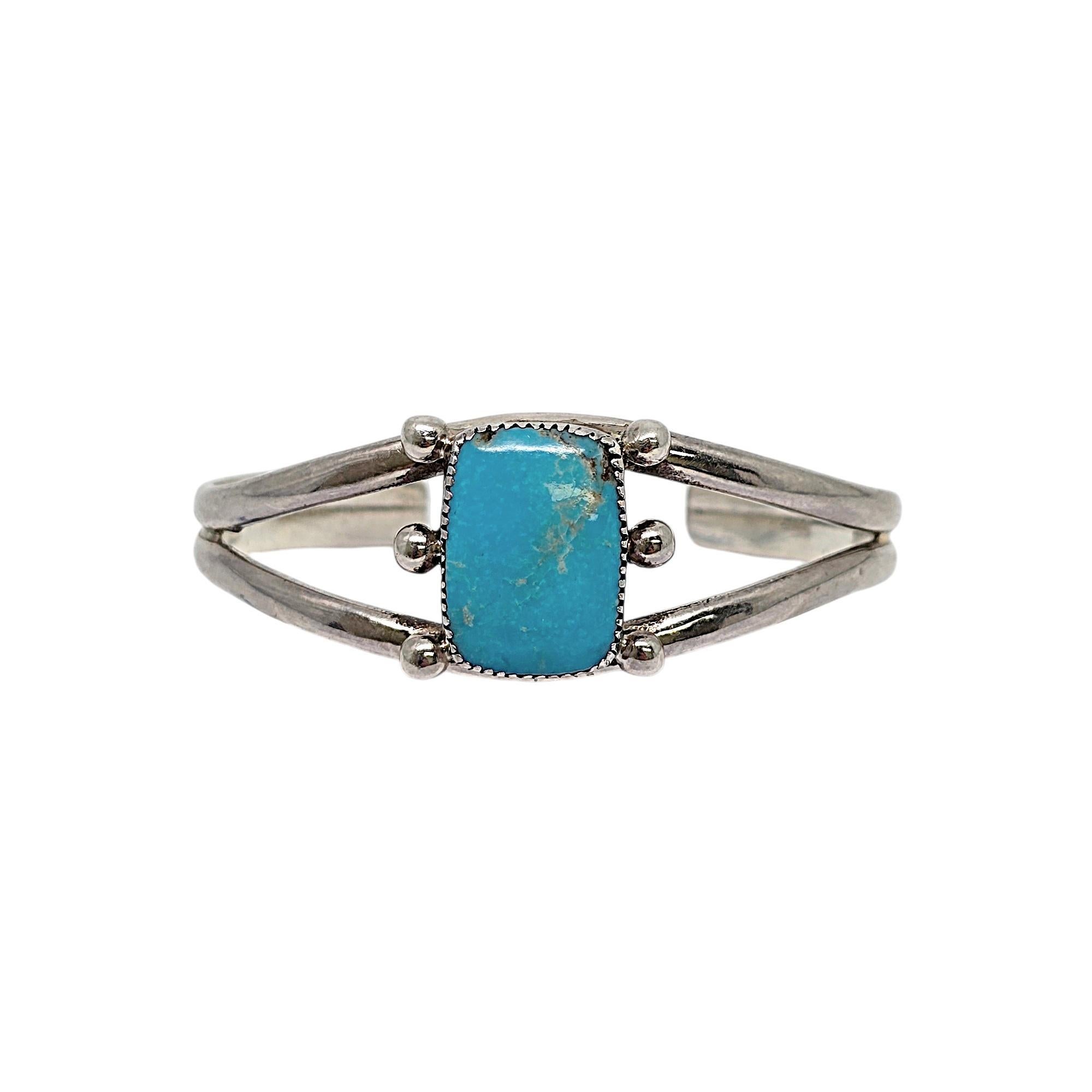 Sterling silver and turquoise cuff bracelet by Native American artisan signed BM.

This bracelet features a large rectangular turquoise stone in a saw tooth bezel with small bead accents on each side of the stone.

Weighs approx 23.9g,