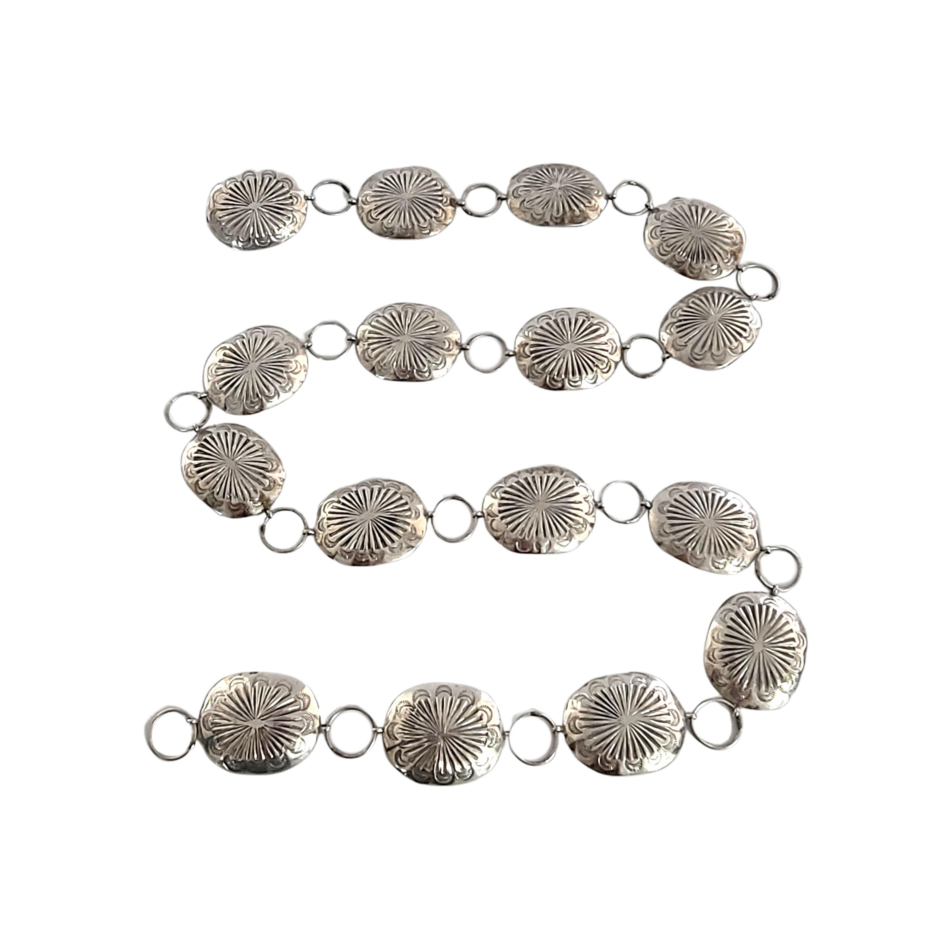 Vintage silver concho belt chain.

This belt chain is a beautiful example of Native American artisan craftsmanship, featuring stamped design on 16 conchos alternating with round links.

Measures approx 37