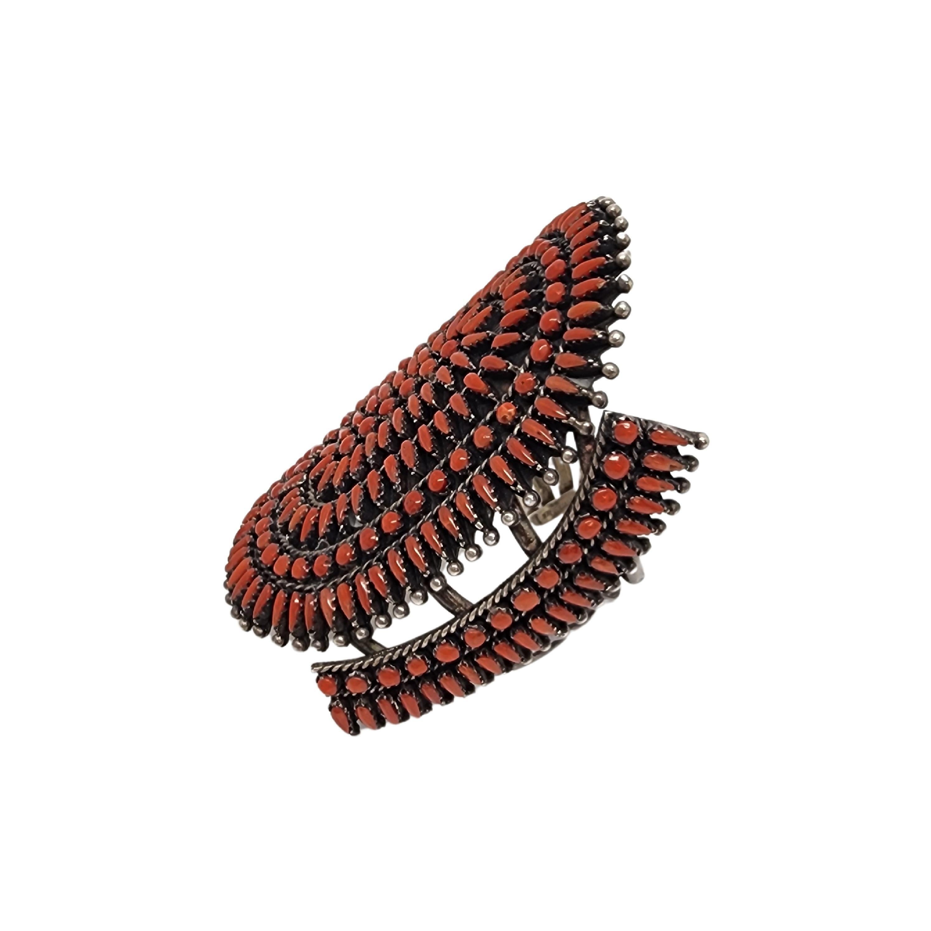 Silver coral petit point cuff bracelet by Native American artisan.

This large and substantial piece is a beautiful example of Zuni clusterwork featuring small, long, narrow, pear shaped red coral stones.

Weighs approx 92.5g, 59.5dwt

Measures
