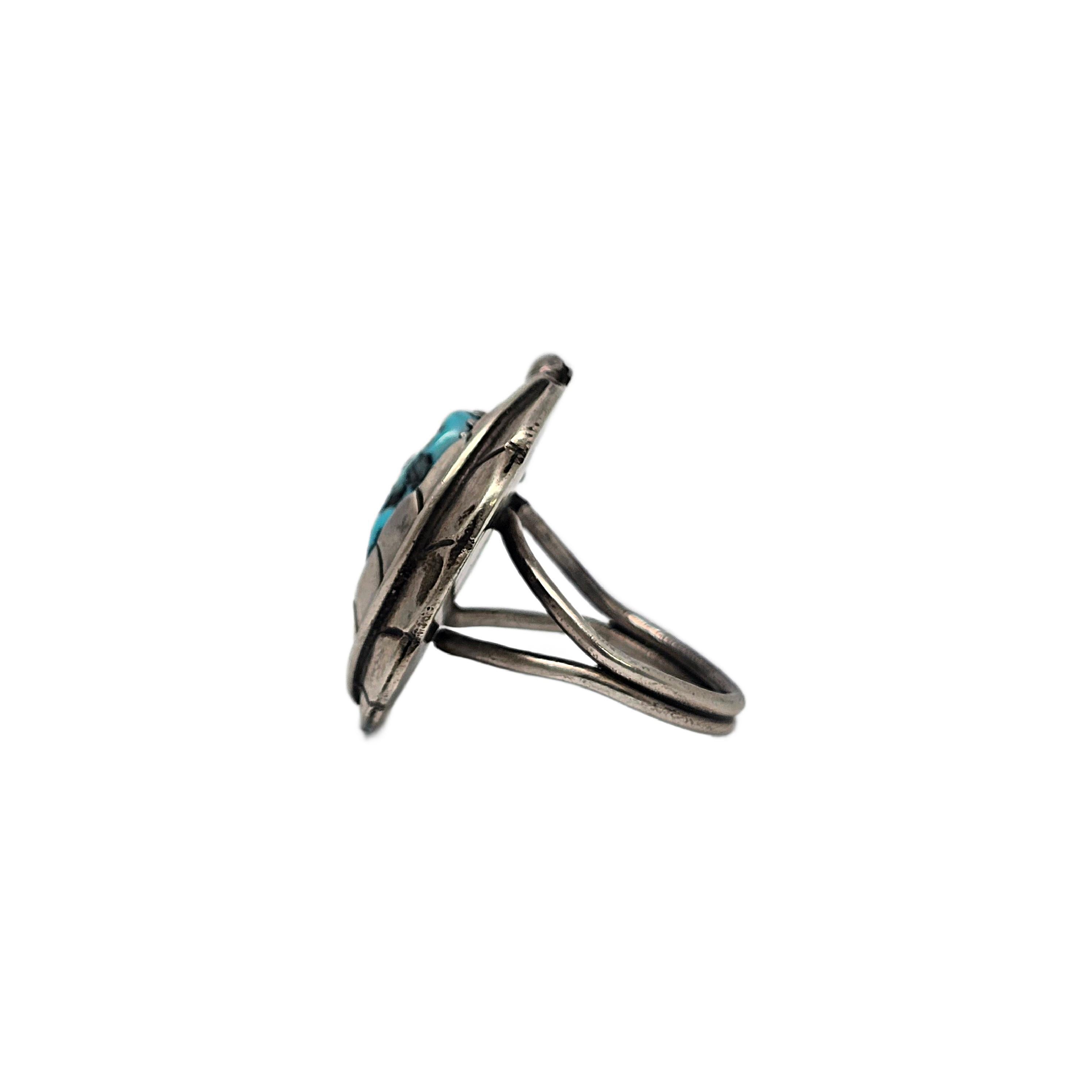 Silver feather and blue turquoise ring by Native American artisan.

Size 7 3/4

A kidney bean shaped turquoise stone in a sawtooth bezel setting with twist rope accent and framed with an overlay silver feather.

Weighs approx 7.7g, 11.9dwt

Measures