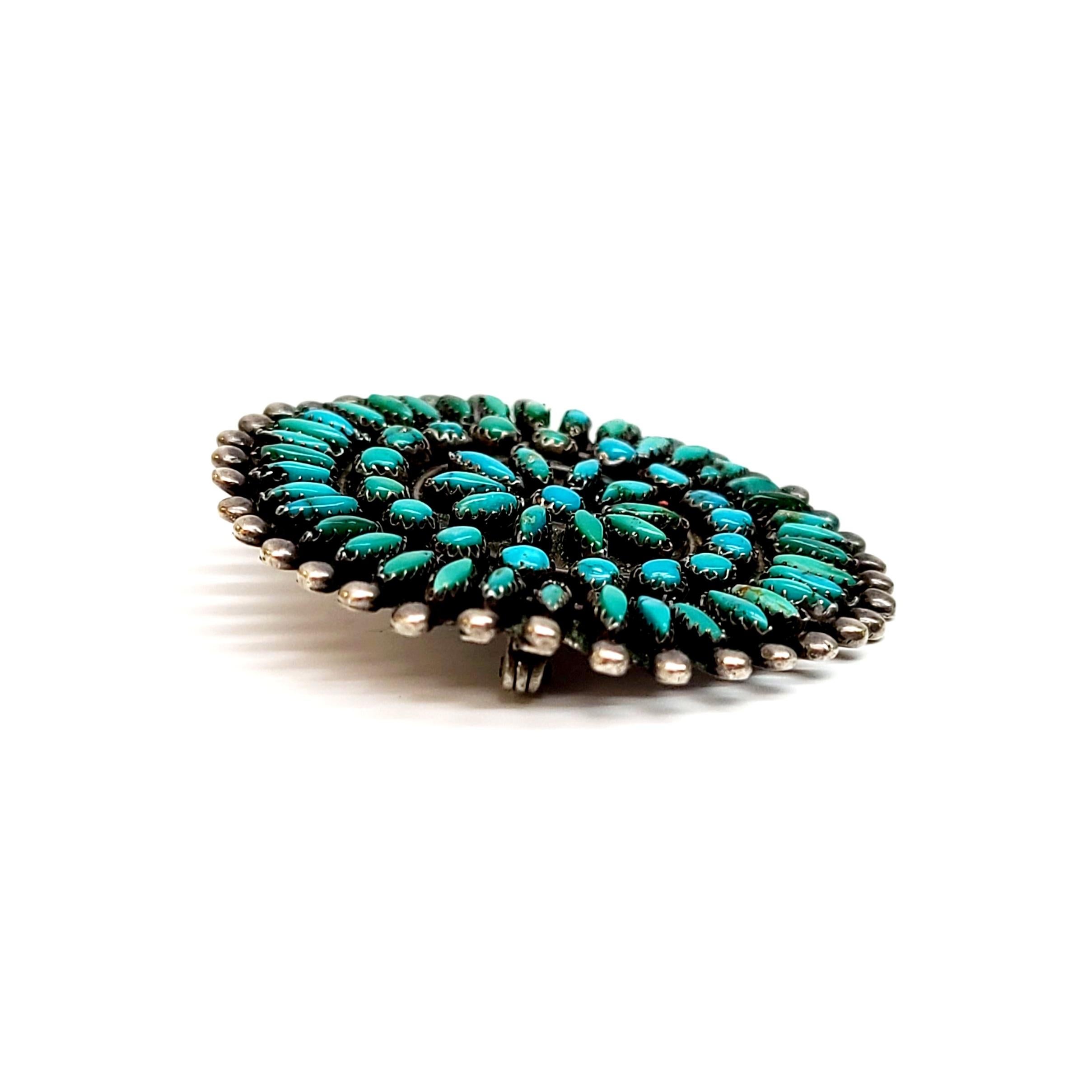 Silver and needlepoint stones round pin by a Native American artisan.

Needlepoint is a Zuni and Navajo technique featuring straight, long narrow stones pointed on each side. This piece is done in a starburst design with silver beaded edge